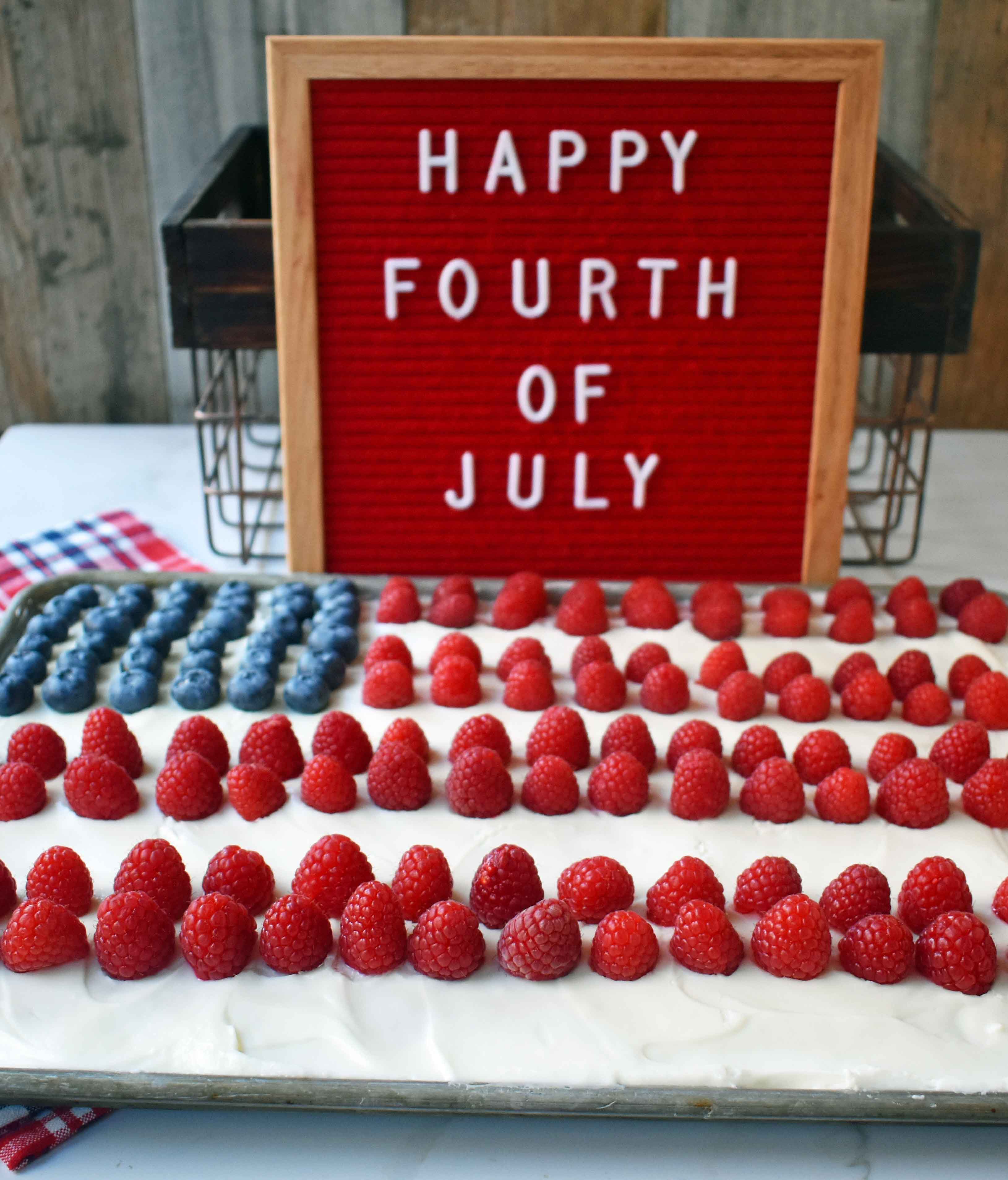 Vanilla Almond White Texas Sheet Cake. A vanilla white cake poured to a jelly roll pan and baked until moist and tender. Topped with almond cream cheese frosting and fresh berries. Perfect flag cake for a 4th of July celebration. www.modernhoney.com