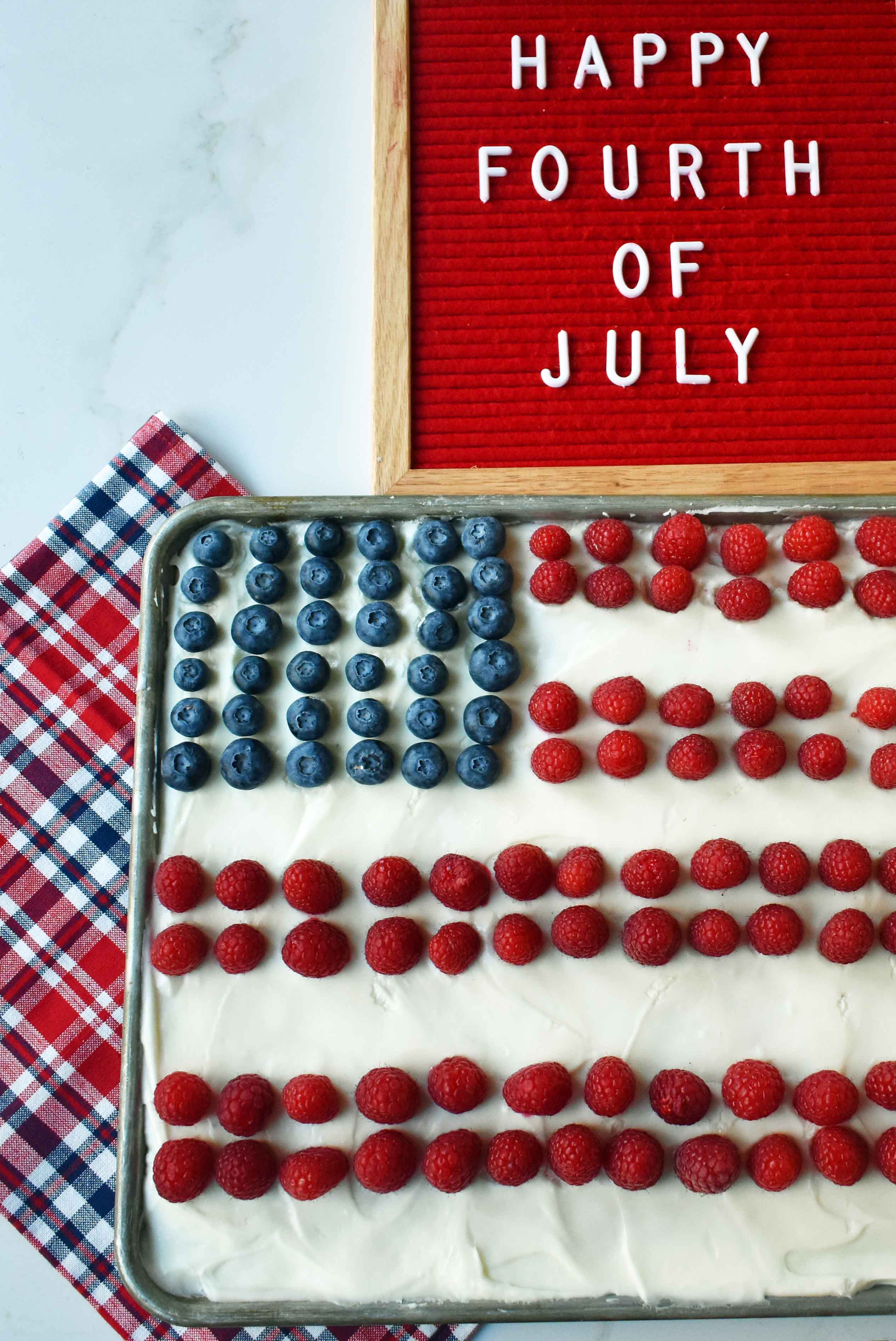 Vanilla Almond White Texas Sheet Cake. A vanilla white cake poured to a jelly roll pan and baked until moist and tender. Topped with almond cream cheese frosting and fresh berries. Perfect flag cake for a 4th of July celebration. www.modernhoney.com