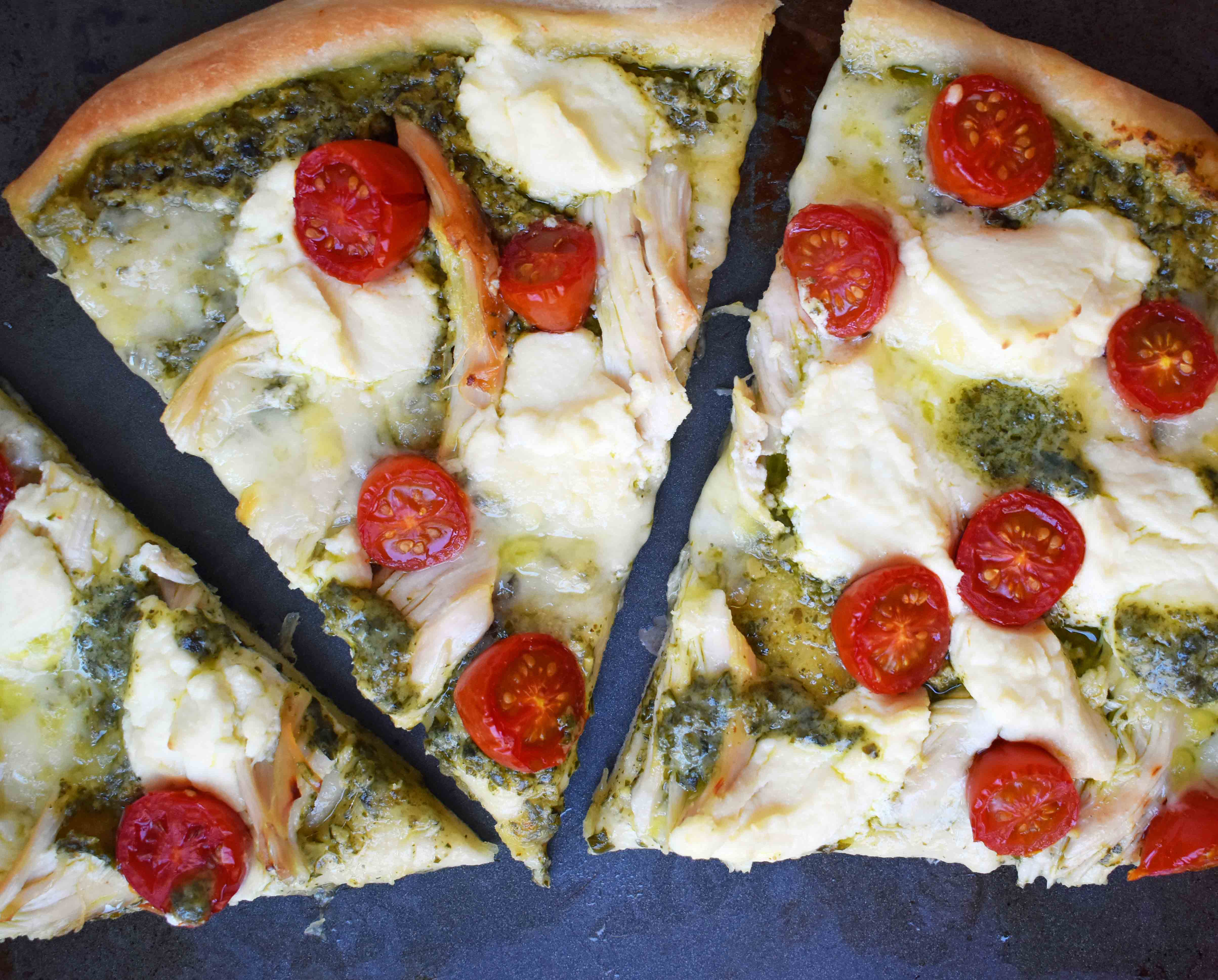 Chicken Pesto Pizza made with only 5 ingredients -- refrigerated pizza dough, pesto sauce, rotisserie chicken, ricotta cheese, and fresh mozzarella. May add grape tomatoes if so desired. An easy, flavorful homemade white pizza. www.modernhoney.com