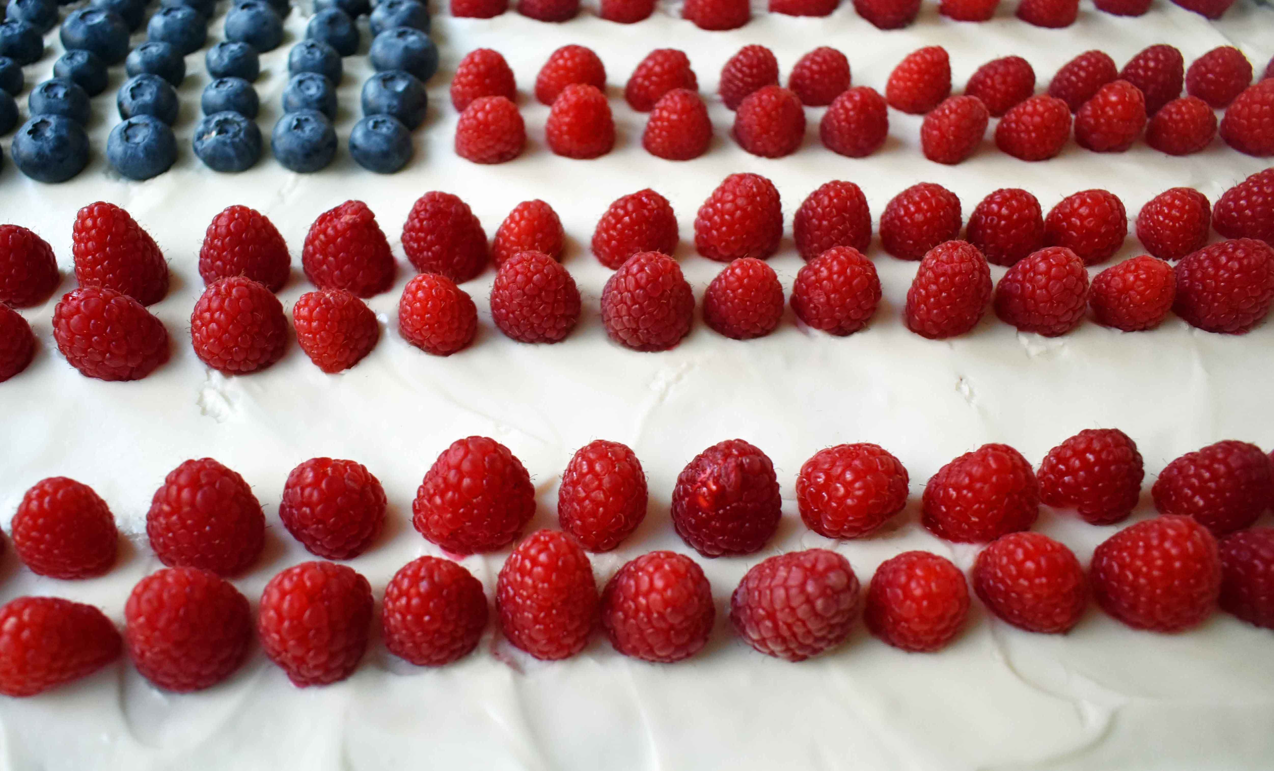 Vanilla Almond White Texas Sheet Cake. A vanilla white cake poured to a jelly roll pan and baked until moist and tender. Topped with almond cream cheese frosting and fresh berries. Perfect flag cake for a 4th of July celebration. www.modernhoney.com