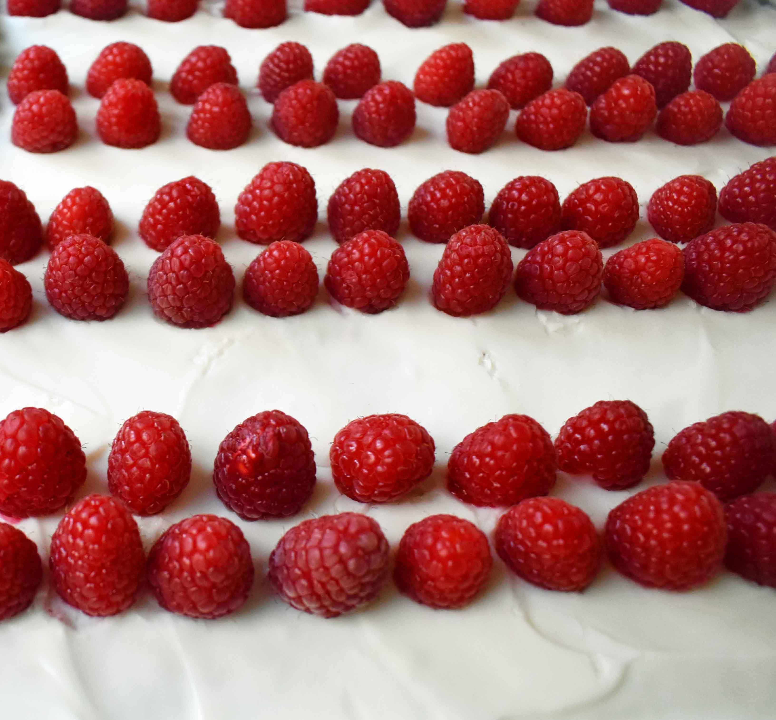 Vanilla Almond White Texas Sheet Cake. A vanilla white cake poured to a jelly roll pan and baked until moist and tender. Topped with almond cream cheese frosting and fresh berries. Perfect flag cake for a 4th of July celebration. www.modernhoney.com
