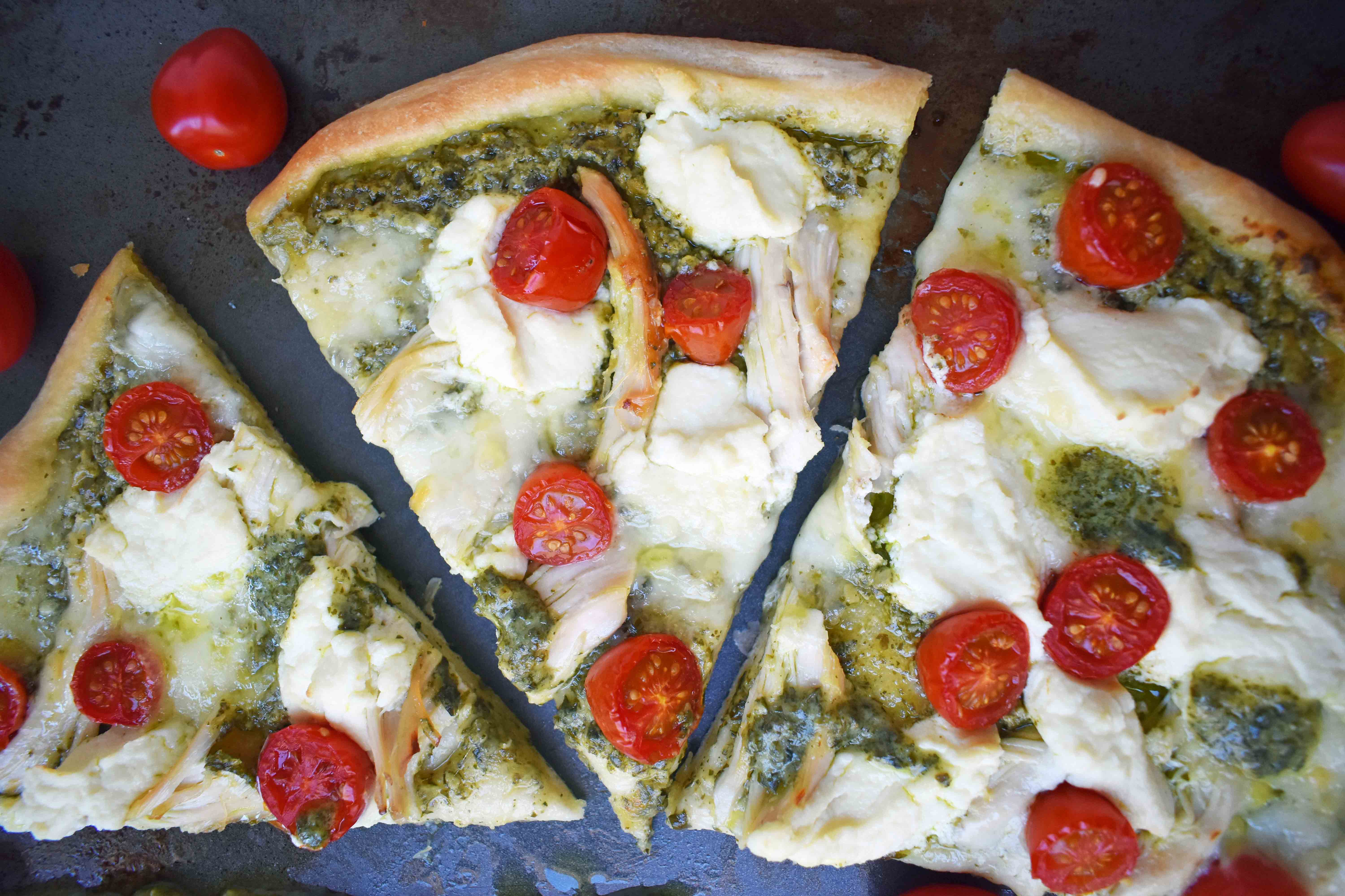 Chicken Pesto Pizza made with only 5 ingredients -- refrigerated pizza dough, pesto sauce, rotisserie chicken, ricotta cheese, and fresh mozzarella. May add grape tomatoes if so desired. An easy, flavorful homemade white pizza. www.modernhoney.com