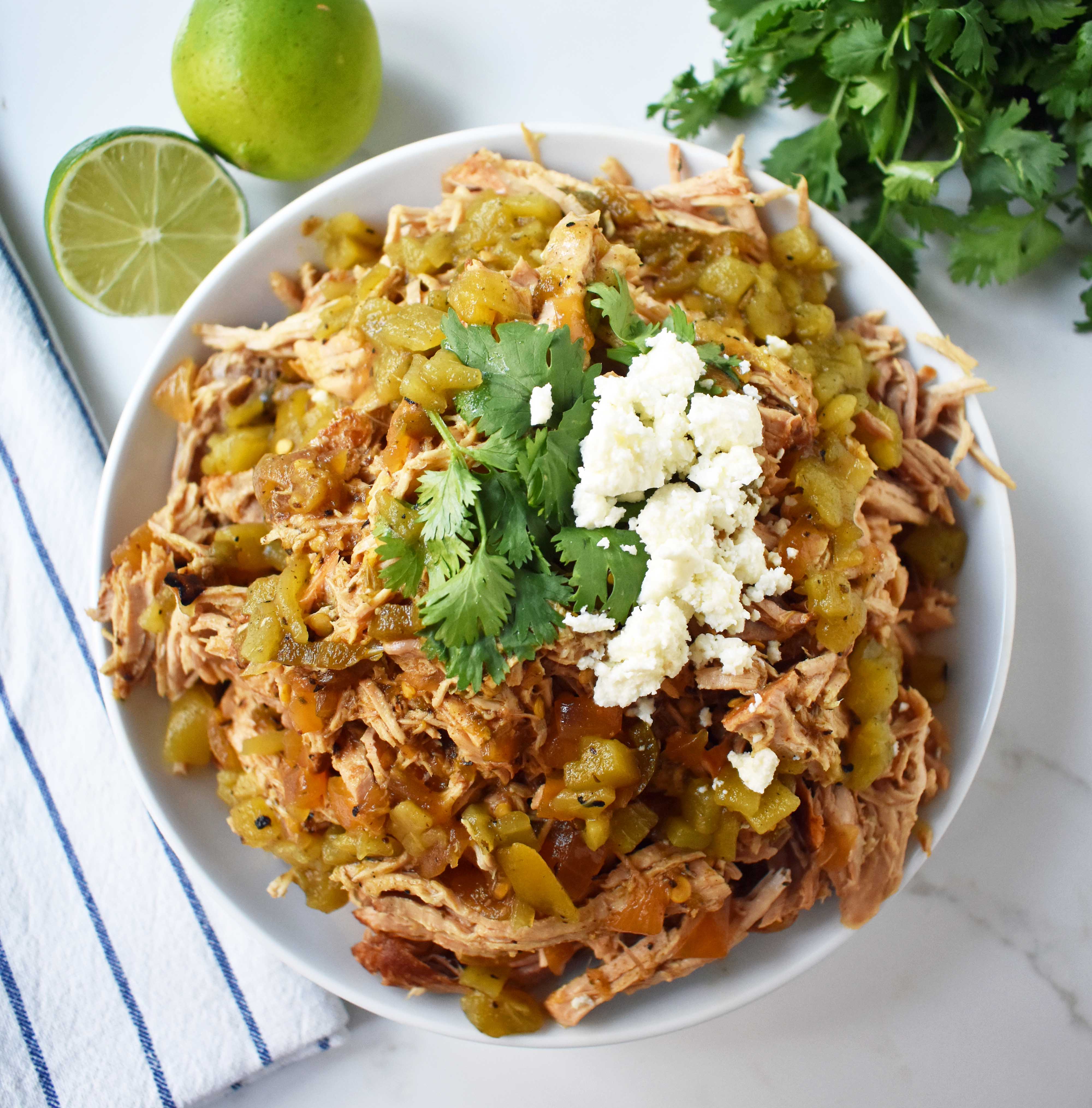 Green Chili Pork Carnitas Tacos. Slow cooked green chili pork seasoned with Mexican spices and freshly squeezed lime juice placed in a hot corn tortilla and topped with cotija cheese, jalapenos, avocado and cilantro. www.modernhoney.com