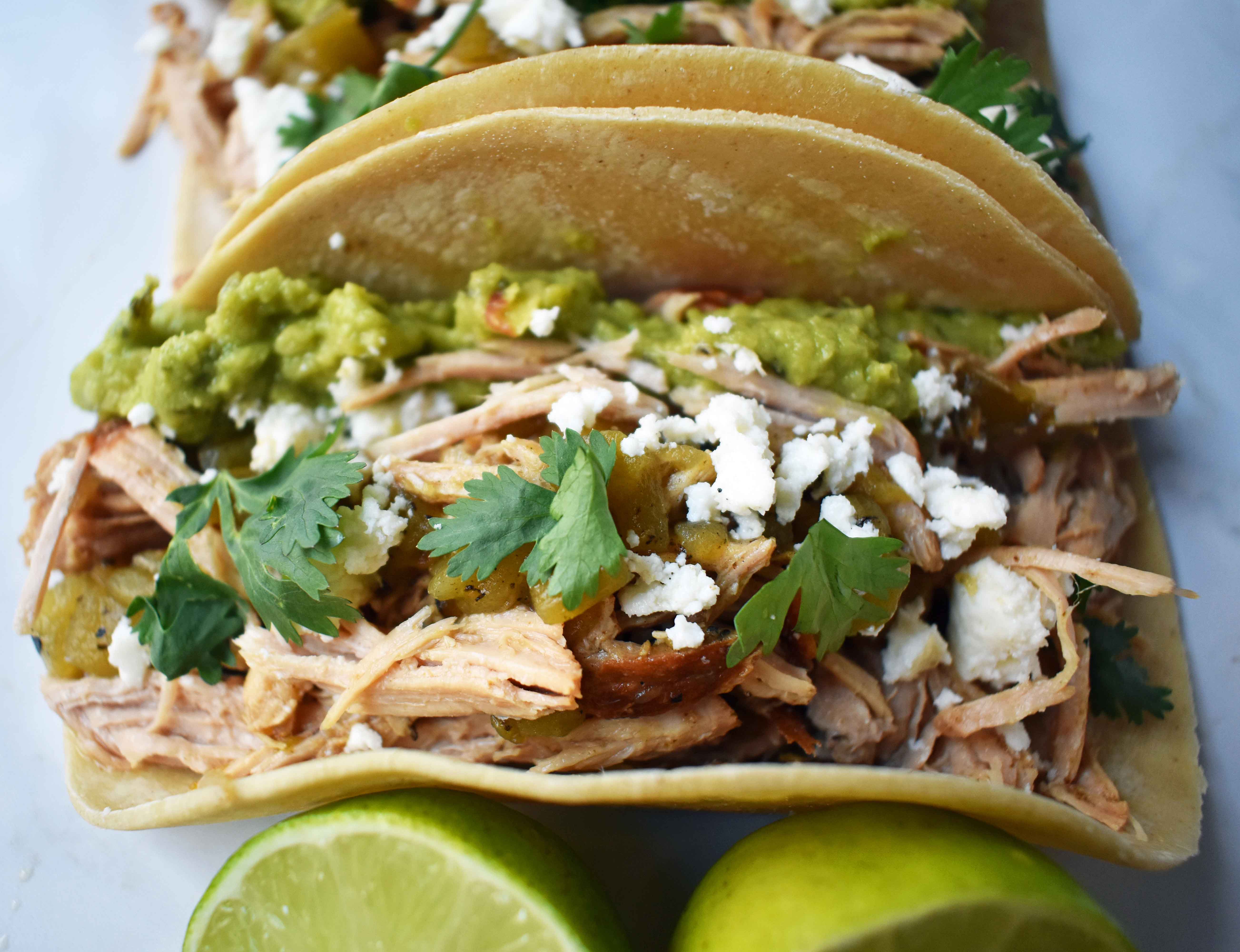 Green Chili Pork Carnitas Tacos. Slow cooked green chili pork seasoned with Mexican spices and freshly squeezed lime juice placed in a hot corn tortilla and topped with cotija cheese, jalapenos, avocado and cilantro. www.modernhoney.com