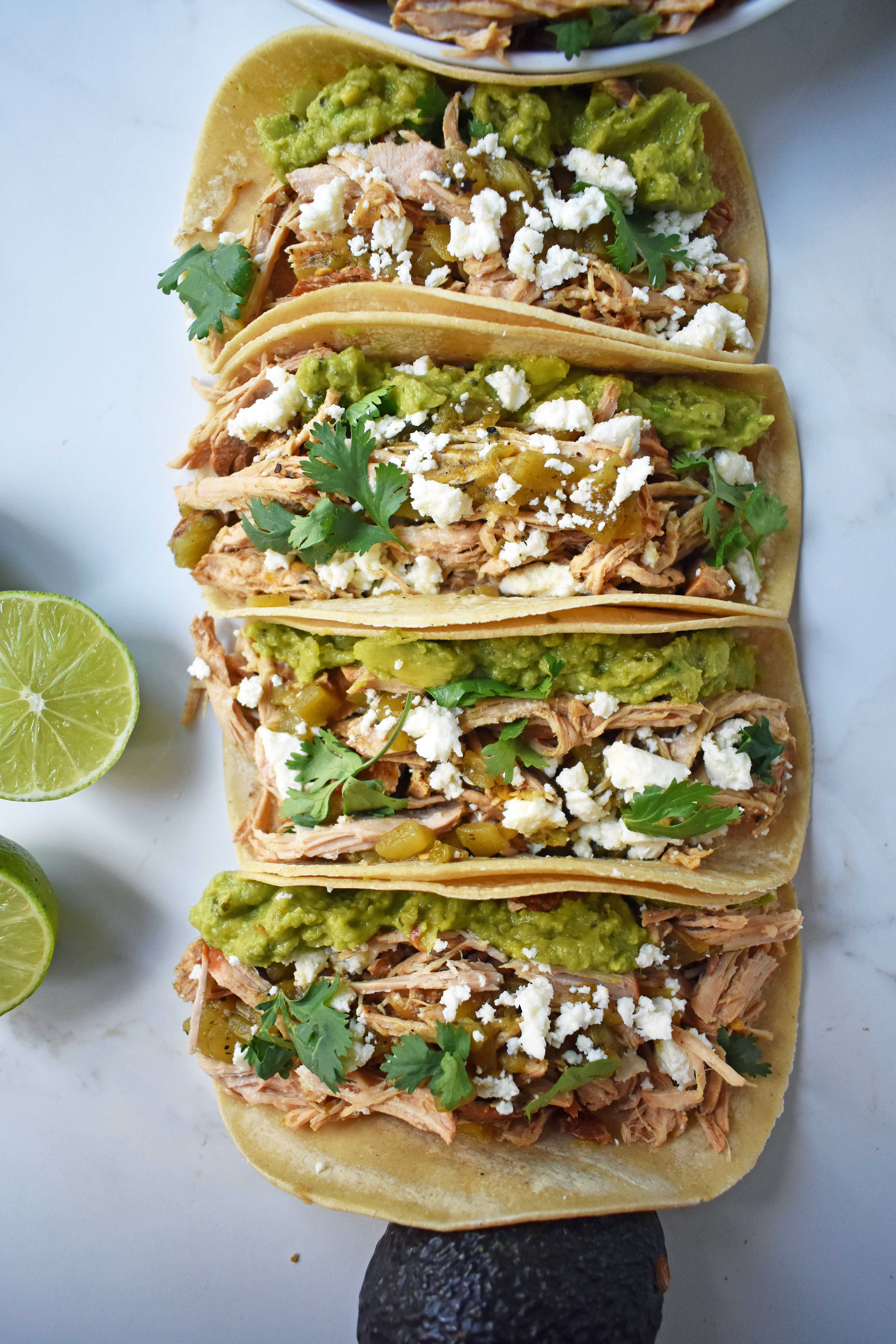 Green Chili Pork Carnitas Tacos. Slow cooked green chili pork seasoned with Mexican spices and freshly squeezed lime juice placed in a hot corn tortilla and topped with cotija cheese, jalapenos, avocado and cilantro. www.modernhoney.com