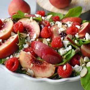 White Peach Raspberry Almond Salad. Fresh white peaches or nectarines, plump raspberries, candied almonds, creamy feta or white cheddar cheese all tossed with a sweet dressing. The perfect summer raspberry peach salad. www.modernhoney.com