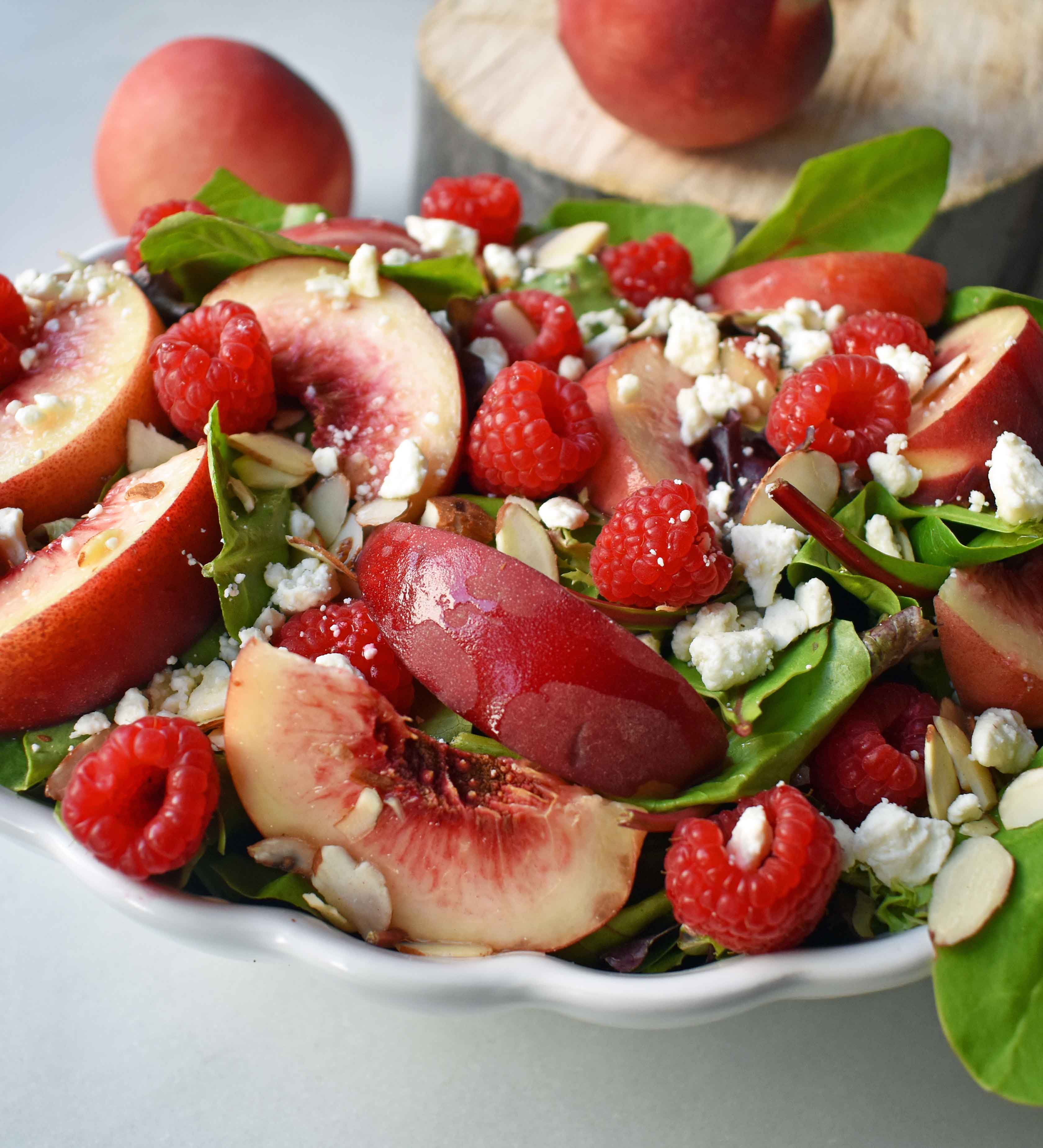 White Peach Raspberry Almond Salad. Fresh white peaches or nectarines, plump raspberries, candied almonds, creamy feta or white cheddar cheese all tossed with a sweet dressing. The perfect summer raspberry peach salad. www.modernhoney.com