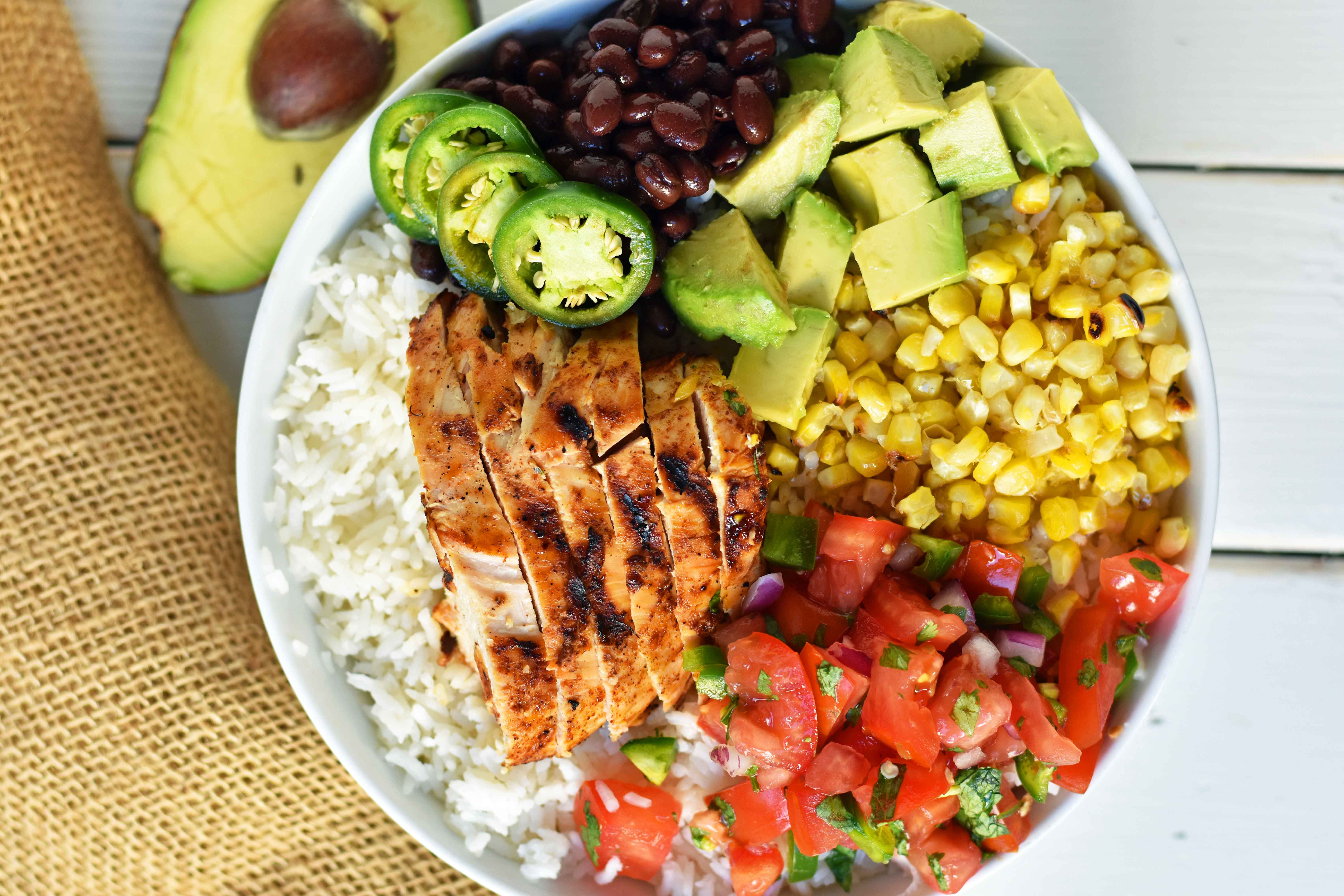 Grilled Chicken Burrito Bowls. Chipotle burrito bowls copycat recipe. Chili lime grilled chicken, pico de gallo, avocado, roasted corn, black beans, rice, and cilantro ranch dressing. A healthy mexican chicken taco bowl. www.modernhoney.com