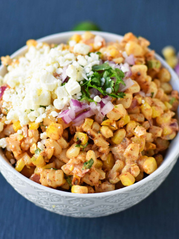 Mexican Street Corn Salad. Mexican Street Corn in a bowl made with roasted corn, mexican spices, lime, cilantro, a touch of mayo, and cotija cheese. A perfect mexican side dish or mexican appetizer. This street corn is great on tacos too! www.modernhoney.com