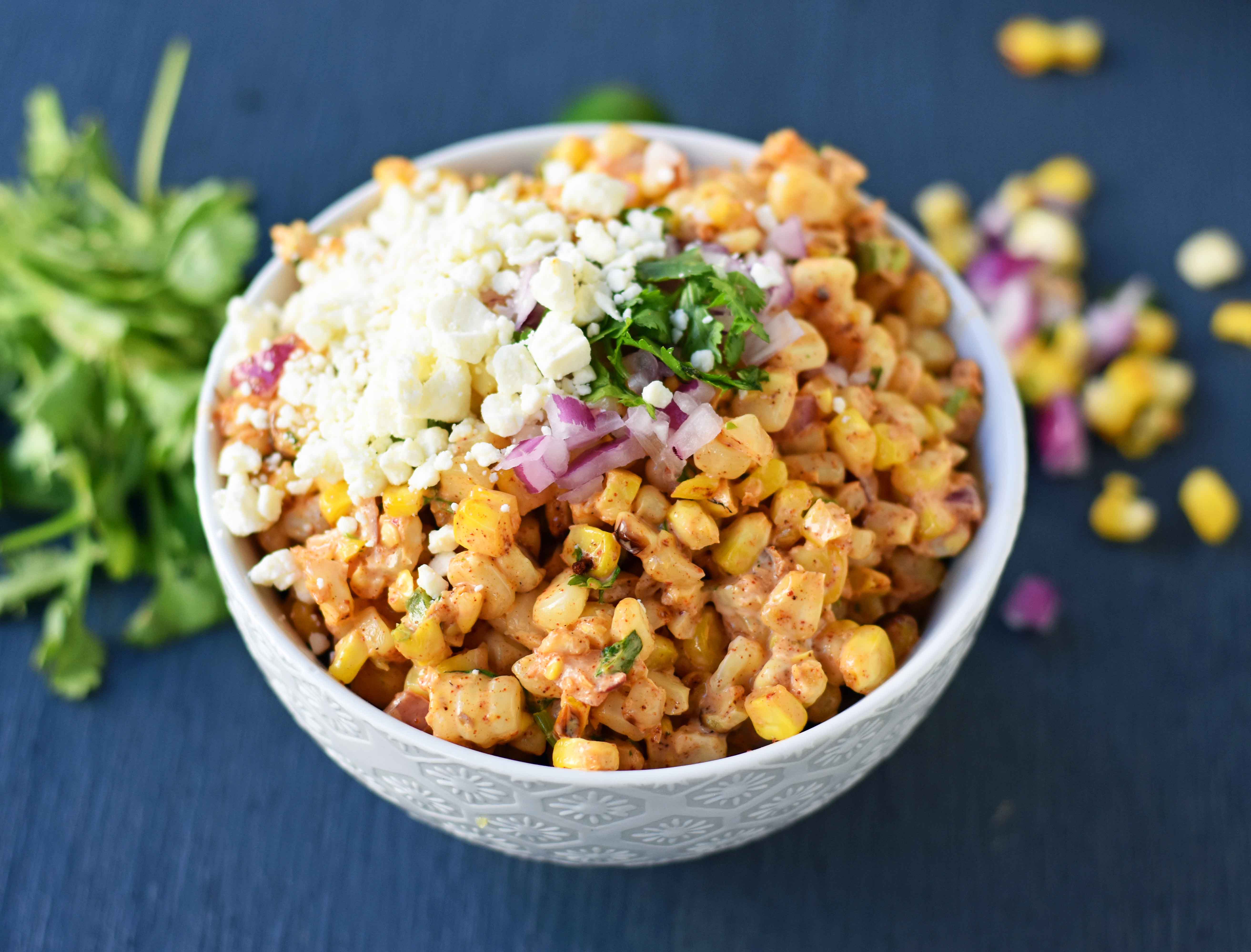 Mexican Street Corn Salad. Mexican Street Corn in a bowl made with roasted corn, mexican spices, lime, cilantro, a touch of mayo, and cotija cheese. A perfect mexican side dish or mexican appetizer. This street corn is great on tacos too! www.modernhoney.com