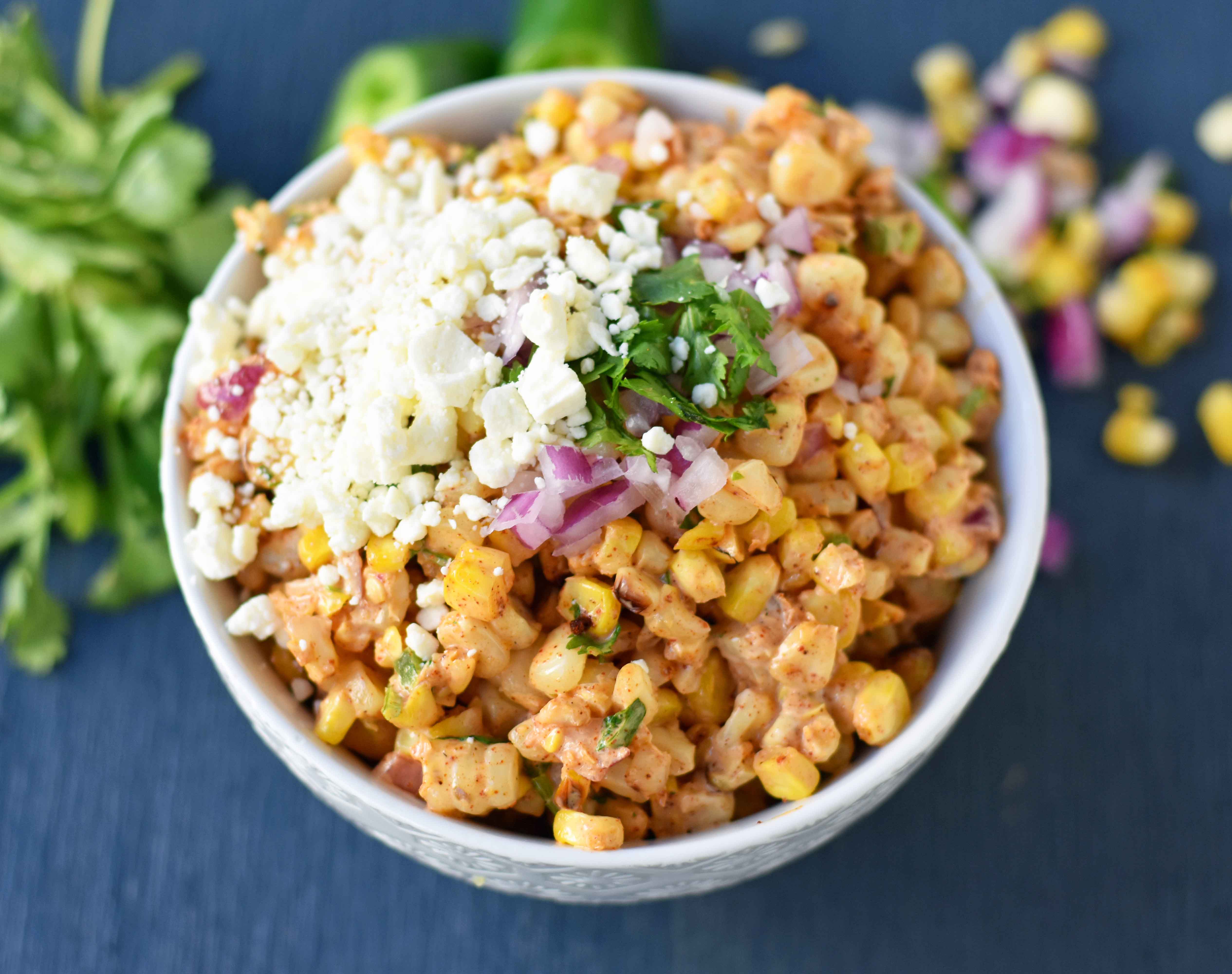 Mexican Street Corn Salad. Mexican Street Corn in a bowl made with roasted corn, mexican spices, lime, cilantro, a touch of mayo, and cotija cheese. A perfect mexican side dish or mexican appetizer. This street corn is great on tacos too! www.modernhoney.com