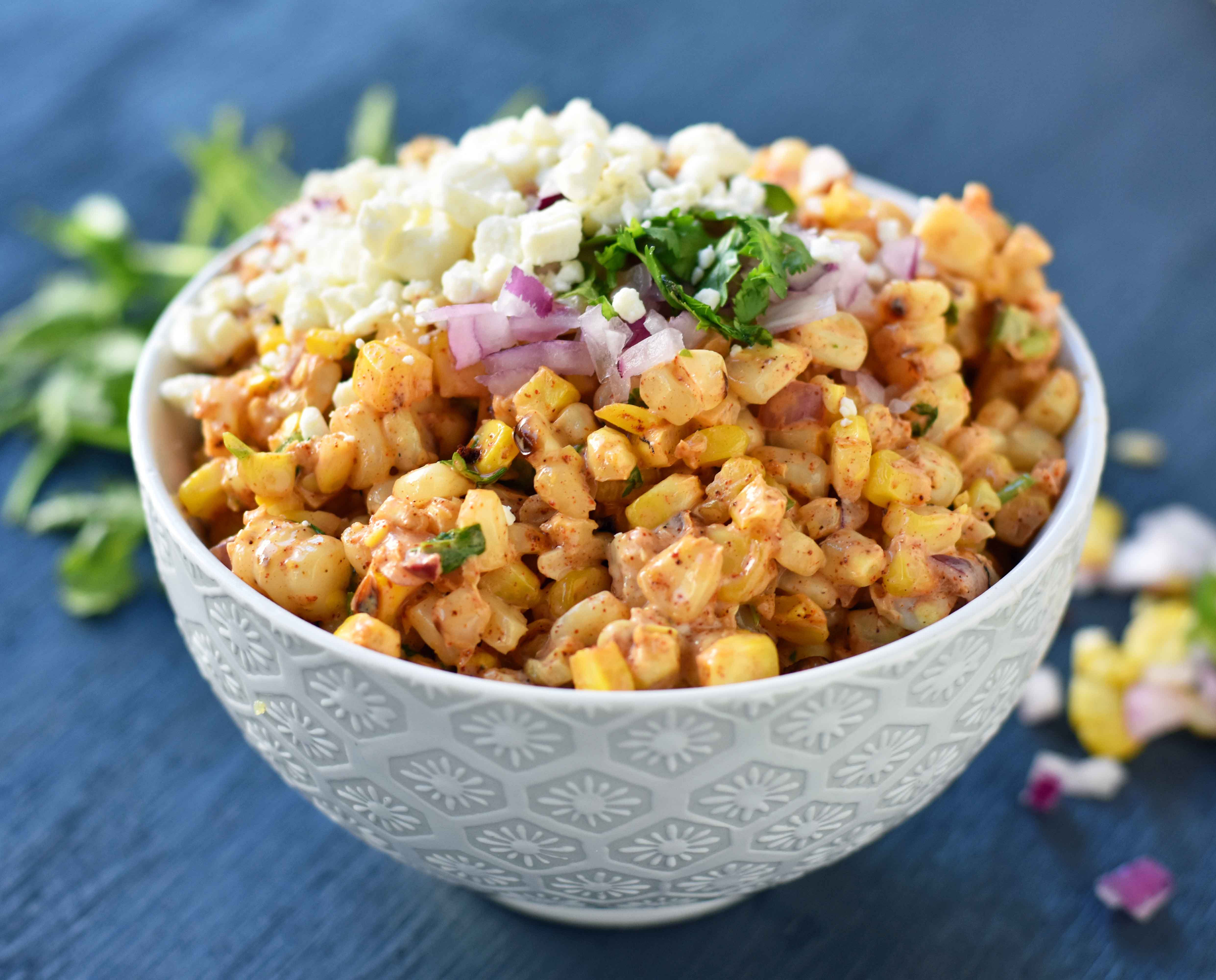 Mexican Street Corn Salad. Mexican Street Corn in a bowl made with roasted corn, mexican spices, lime, cilantro, a touch of mayo, and cotija cheese. A perfect mexican side dish or mexican appetizer. This street corn is great on tacos too! www.modernhoney.com