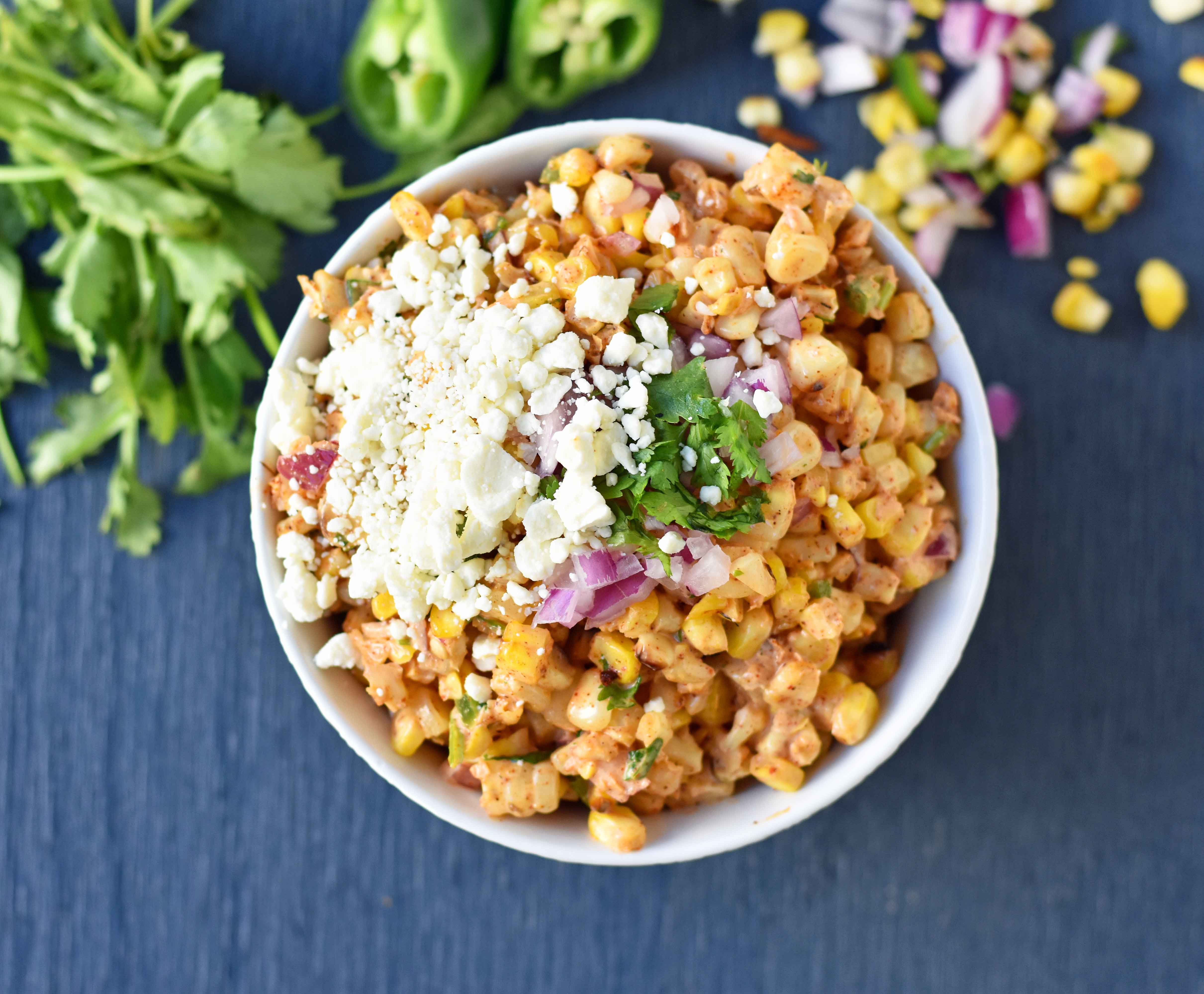 Mexican Street Corn Salad. Mexican Street Corn in a bowl made with roasted corn, mexican spices, lime, cilantro, a touch of mayo, and cotija cheese. A perfect mexican side dish or mexican appetizer. This street corn is great on tacos too! www.modernhoney.com