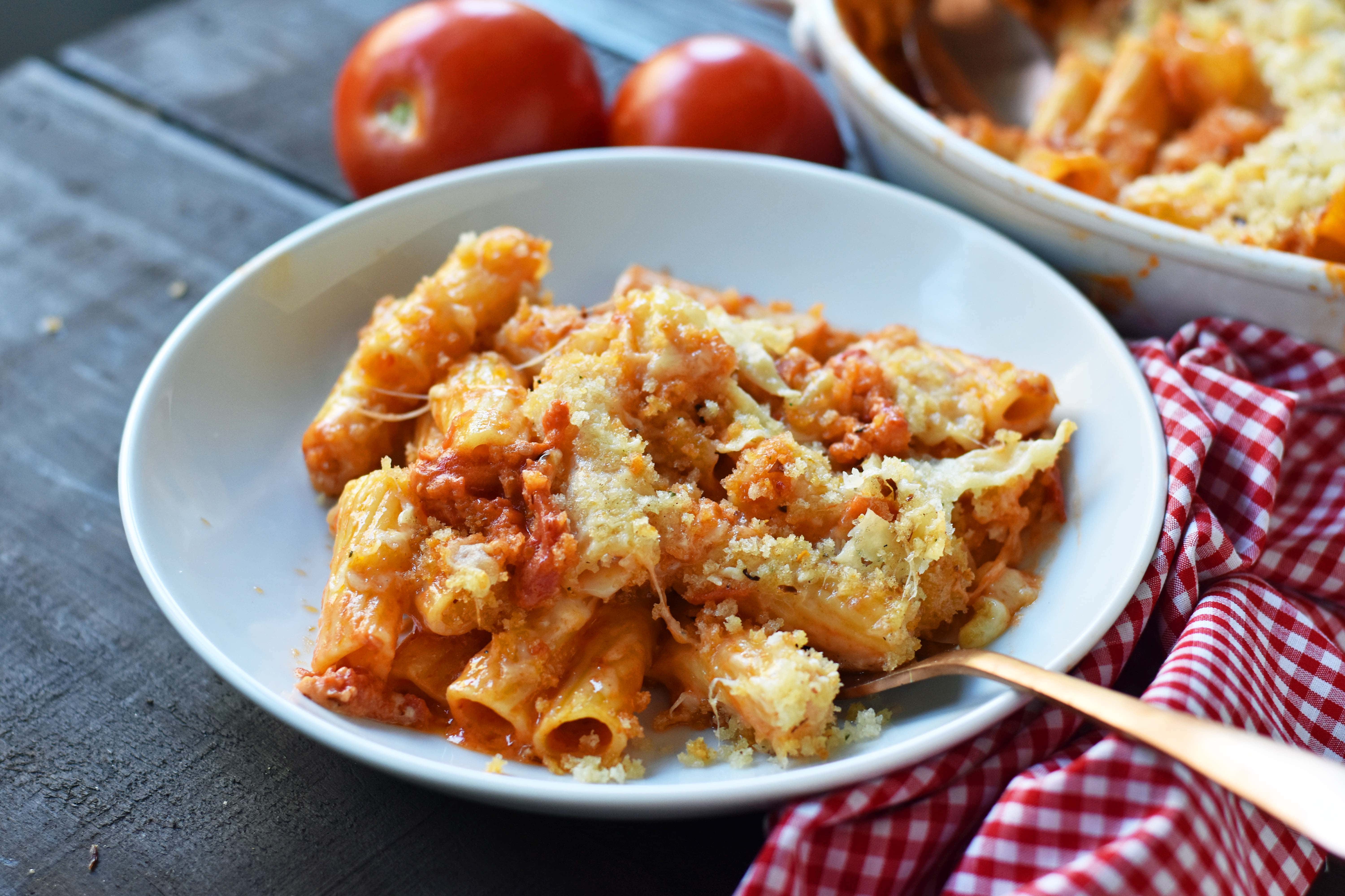 Cheesy Baked Rigatoni. An easy, popular Italian pasta dish. Baked rigatoni or baked ziti with rich and creamy bechamel sauce and homemade marinara sauce topped with parmesan and mozzarella cheeses and with olive oil crunchy topping. A family favorite weeknight pasta dish made in 30 minutes. www.modernhoney.com