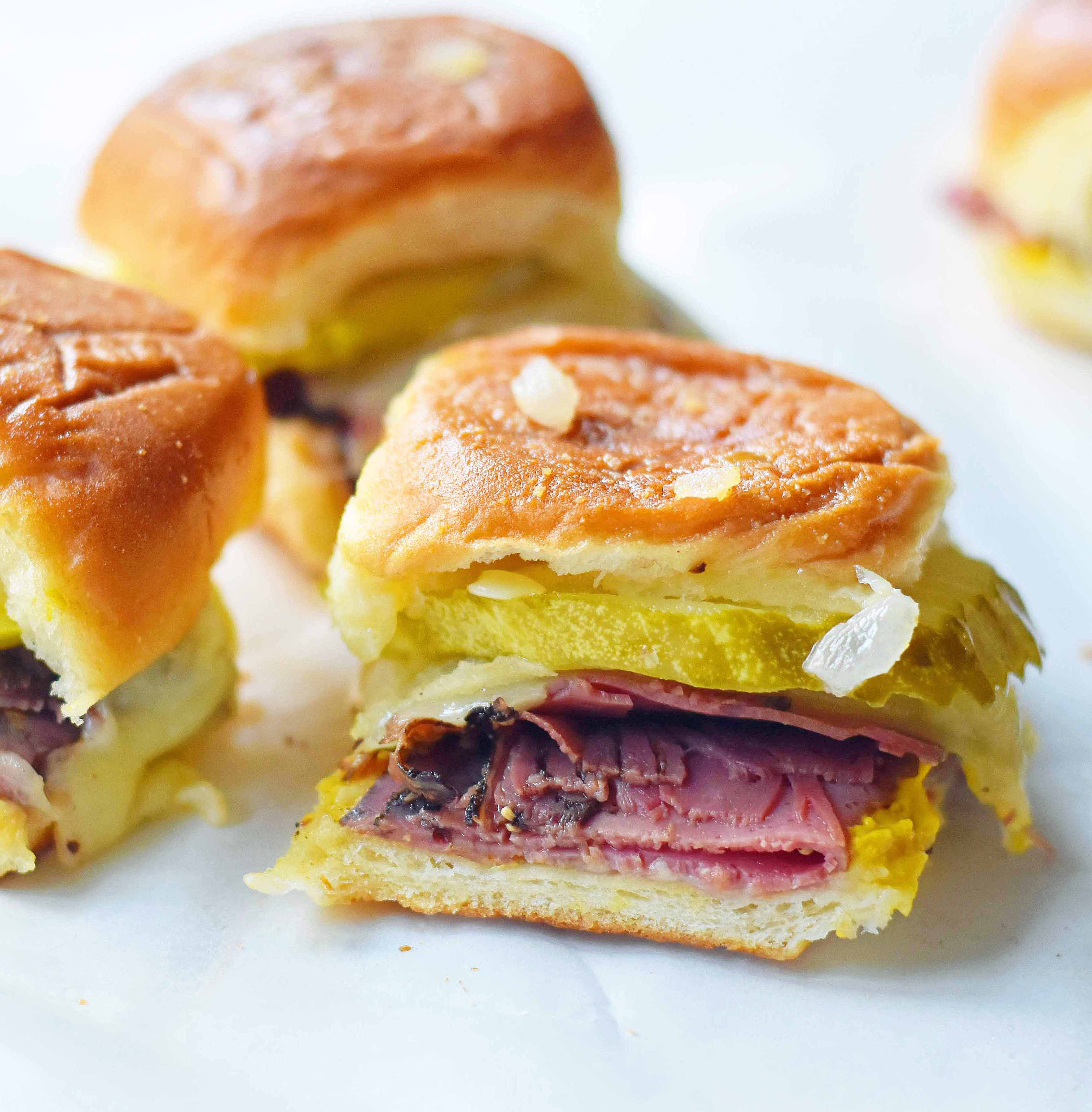 Hot Pastrami and Swiss Tailgate Sliders. Pastrami, creamy swiss, tangy mustard all on a hawaiian roll basted with garlic butter and baked until warm and toasty. A flavorful hot pastrami sandwich that is so easy! Perfect for entertaining, watching a football game, or a dinner at home. www.modernhoney.com