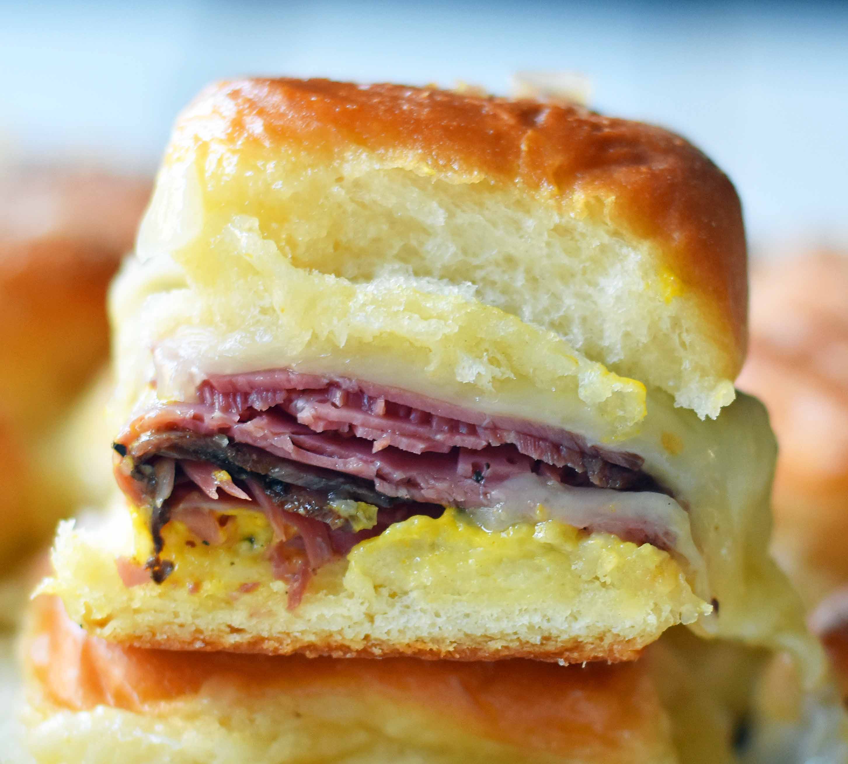 Hot Pastrami and Swiss Tailgate Sliders. Pastrami, creamy swiss, tangy mustard all on a hawaiian roll basted with garlic butter and baked until warm and toasty. A flavorful hot pastrami sandwich that is so easy! Perfect for entertaining, watching a football game, or a dinner at home. www.modernhoney.com