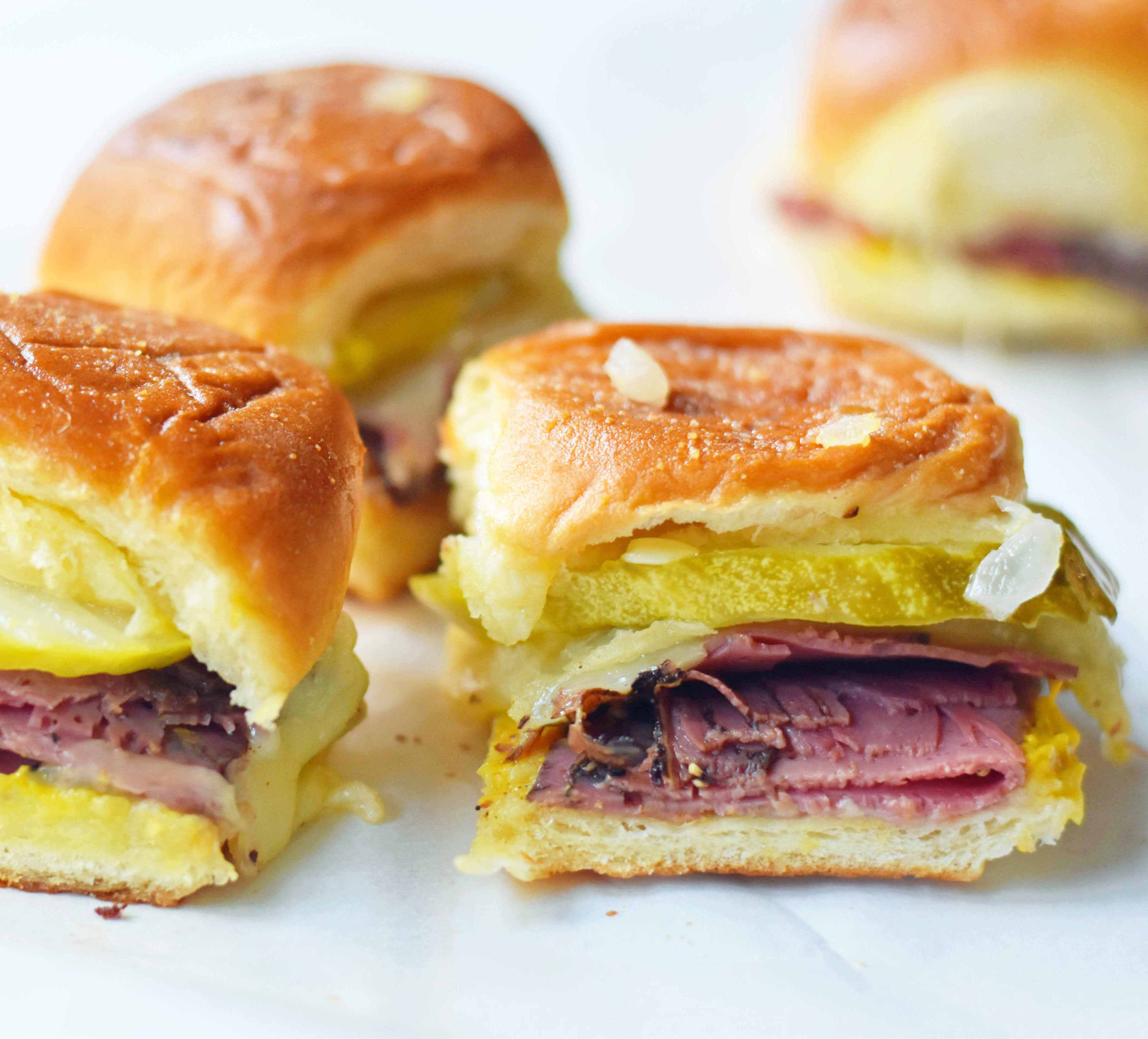 Hot Pastrami and Swiss Tailgate Sliders. Pastrami, creamy swiss, tangy mustard all on a hawaiian roll basted with garlic butter and baked until warm and toasty. A flavorful hot pastrami sandwich that is so easy! Perfect for entertaining, watching a football game, or a dinner at home. www.modernhoney.com