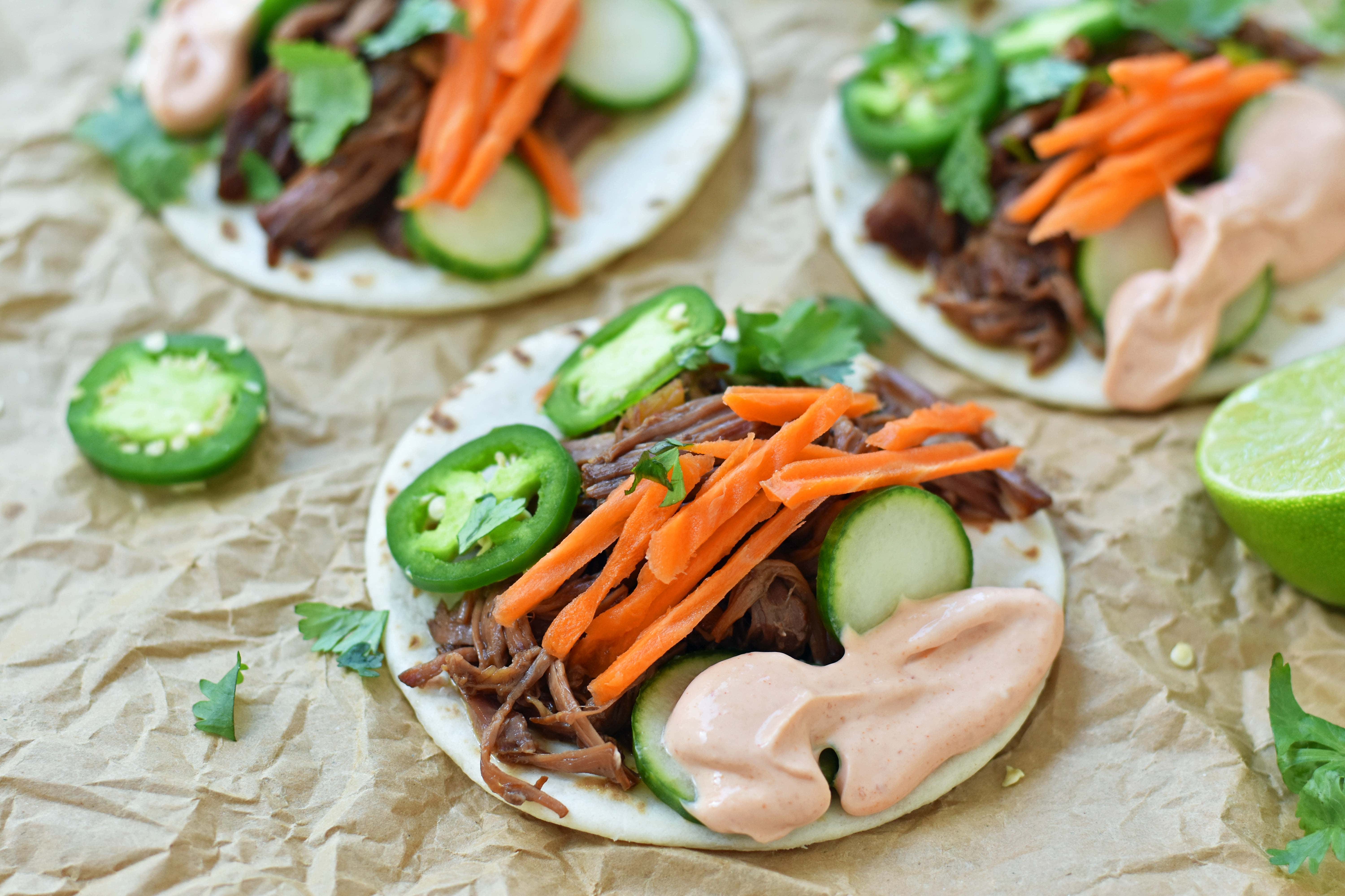 Slow Cooker Instant Pot Korean Beef Tacos. Slowly simmered korean beef with asian spices and topped with crunchy slaw. An easy weeknight dinner that is a huge hit with the family! www.modernhoney.com