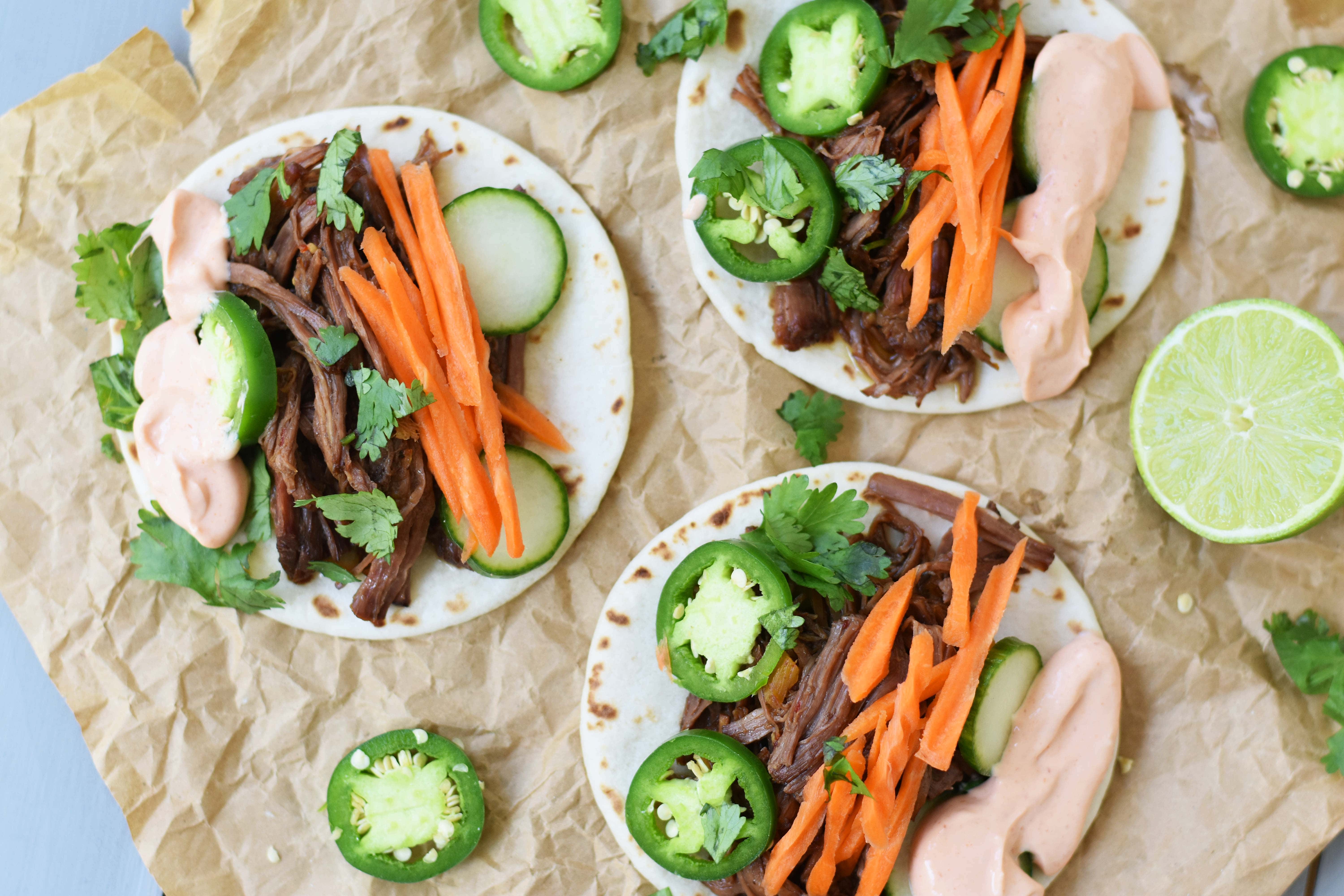 Slow Cooker Instant Pot Korean Beef Tacos. Slowly simmered korean beef with asian spices and topped with crunchy slaw. An easy weeknight dinner that is a huge hit with the family! www.modernhoney.com