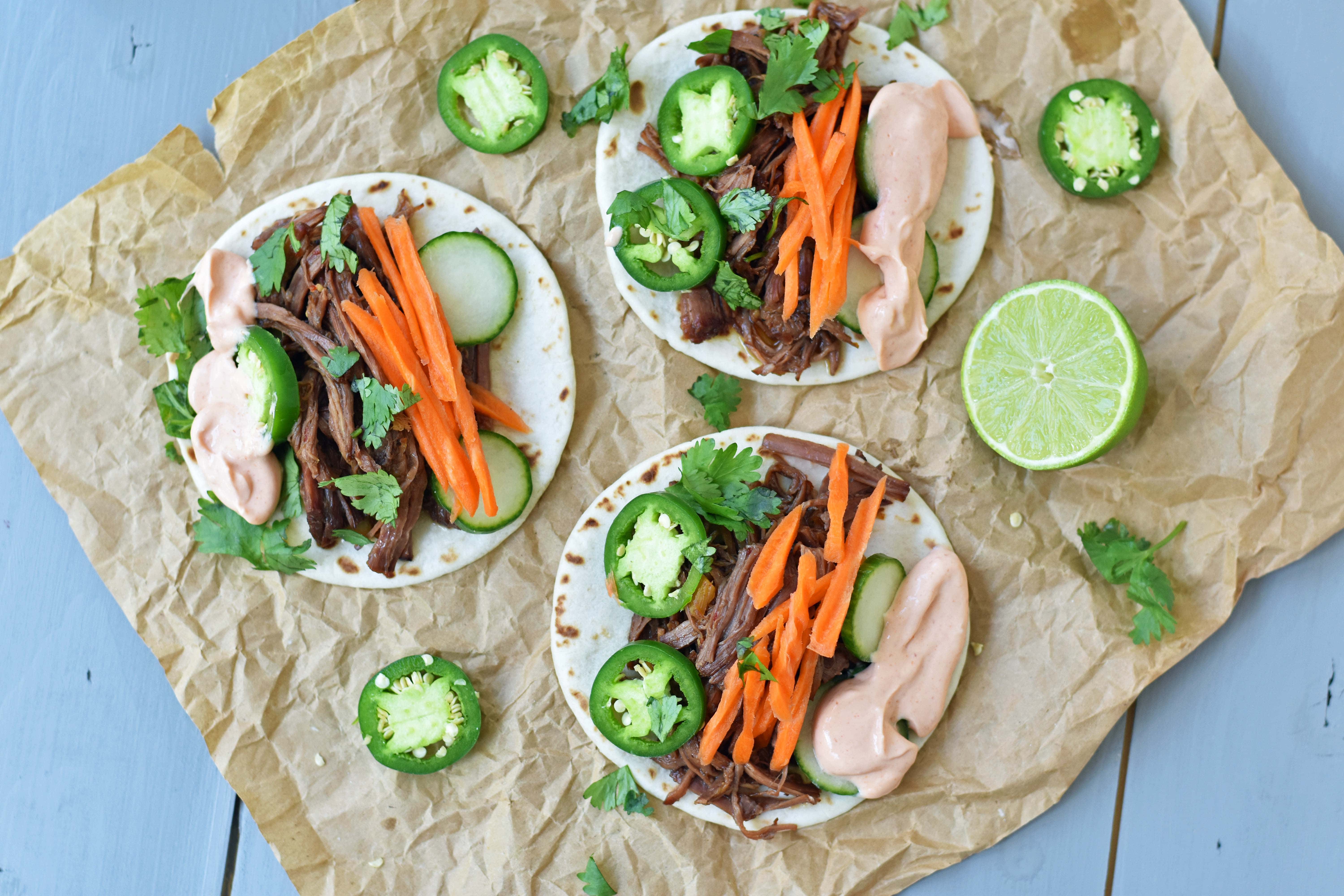 Slow Cooker Instant Pot Korean Beef Tacos. Slowly simmered korean beef with asian spices and topped with crunchy slaw. An easy weeknight dinner that is a huge hit with the family! www.modernhoney.com