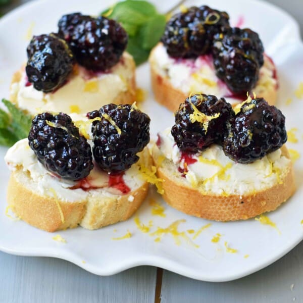 Blackberry and Lemon Mascarpone Crostini. A beautiful appetizer for a bridal shower, baby shower, party, festive holiday party, social gathering or for a dinner at home. A toasted baguette covered in creamy mascarpone cheese and topped with sugar marinated blackberries, fresh lemon zest, and a drizzle of honey. A sophisticated yet delicious appetizer. www.modernhoney.com