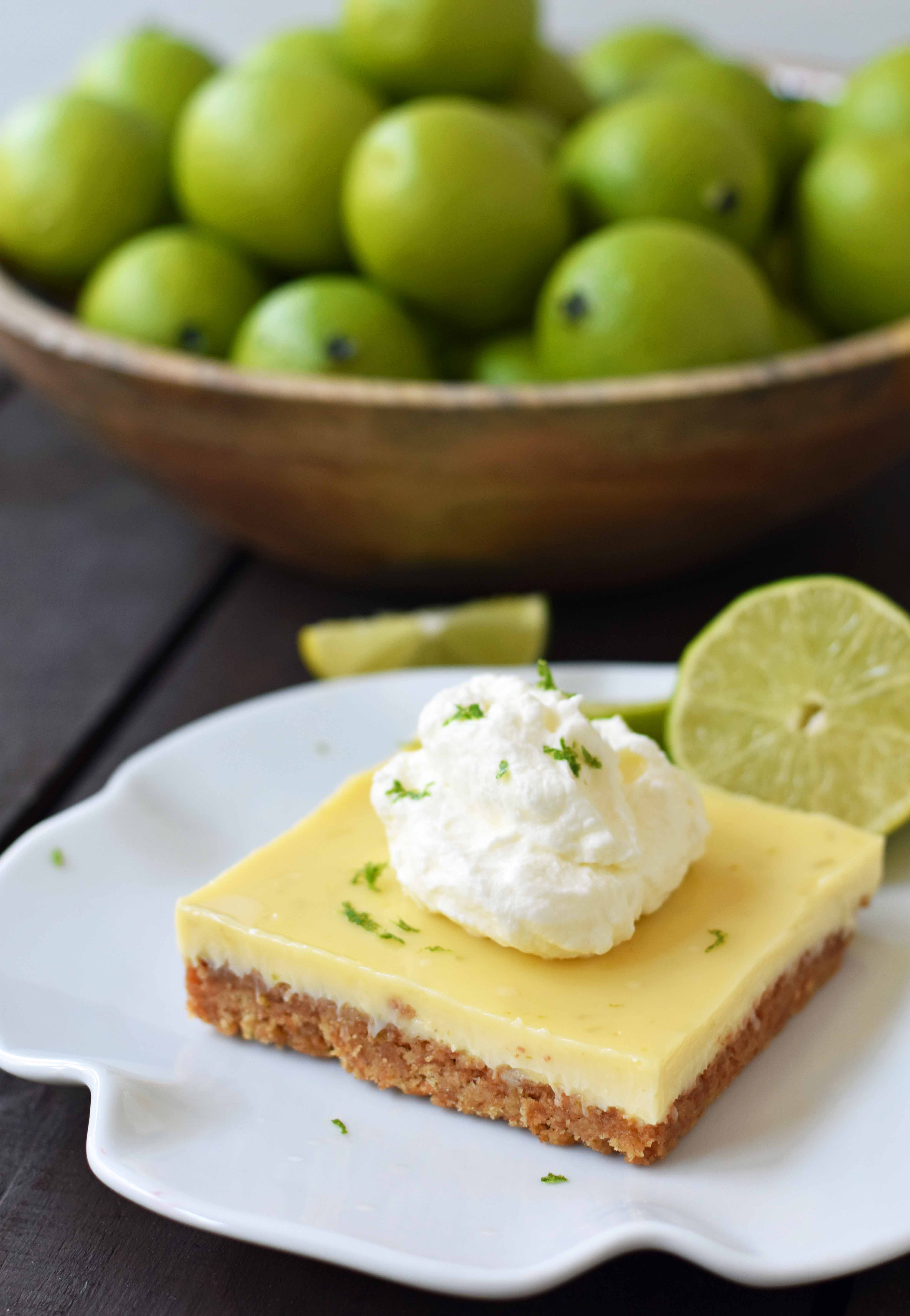 Key Lime Cream Pie Bars made with a buttery graham cracker crust and sweet, tart, and creamy key lime filling and topped with homemade whipped cream. A beautiful and delicious dessert bar recipe. www.modernhoney.com