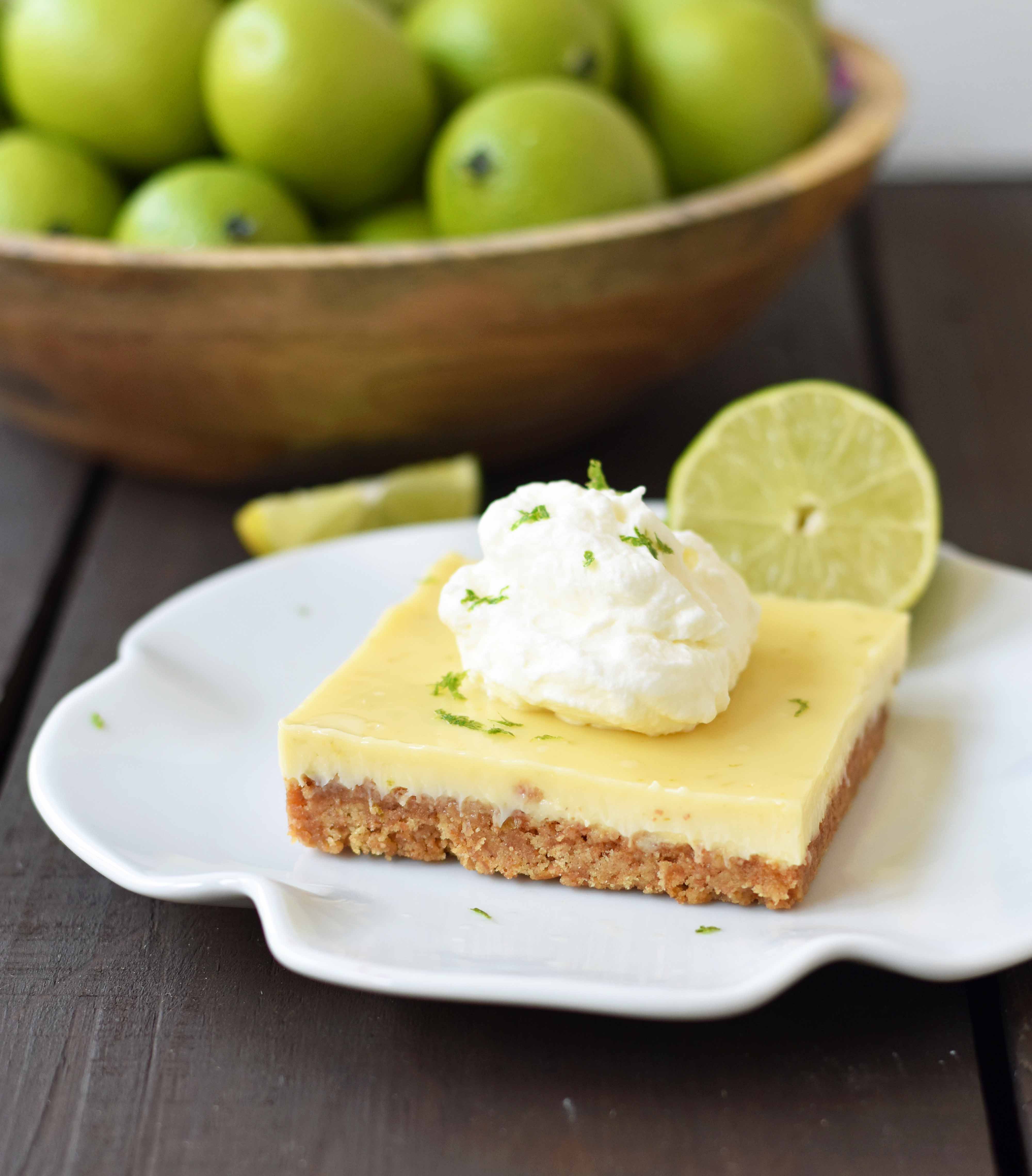 Key Lime Cream Pie Bars made with a buttery graham cracker crust and sweet, tart, and creamy key lime filling and topped with homemade whipped cream. A beautiful and delicious dessert bar recipe. www.modernhoney.com