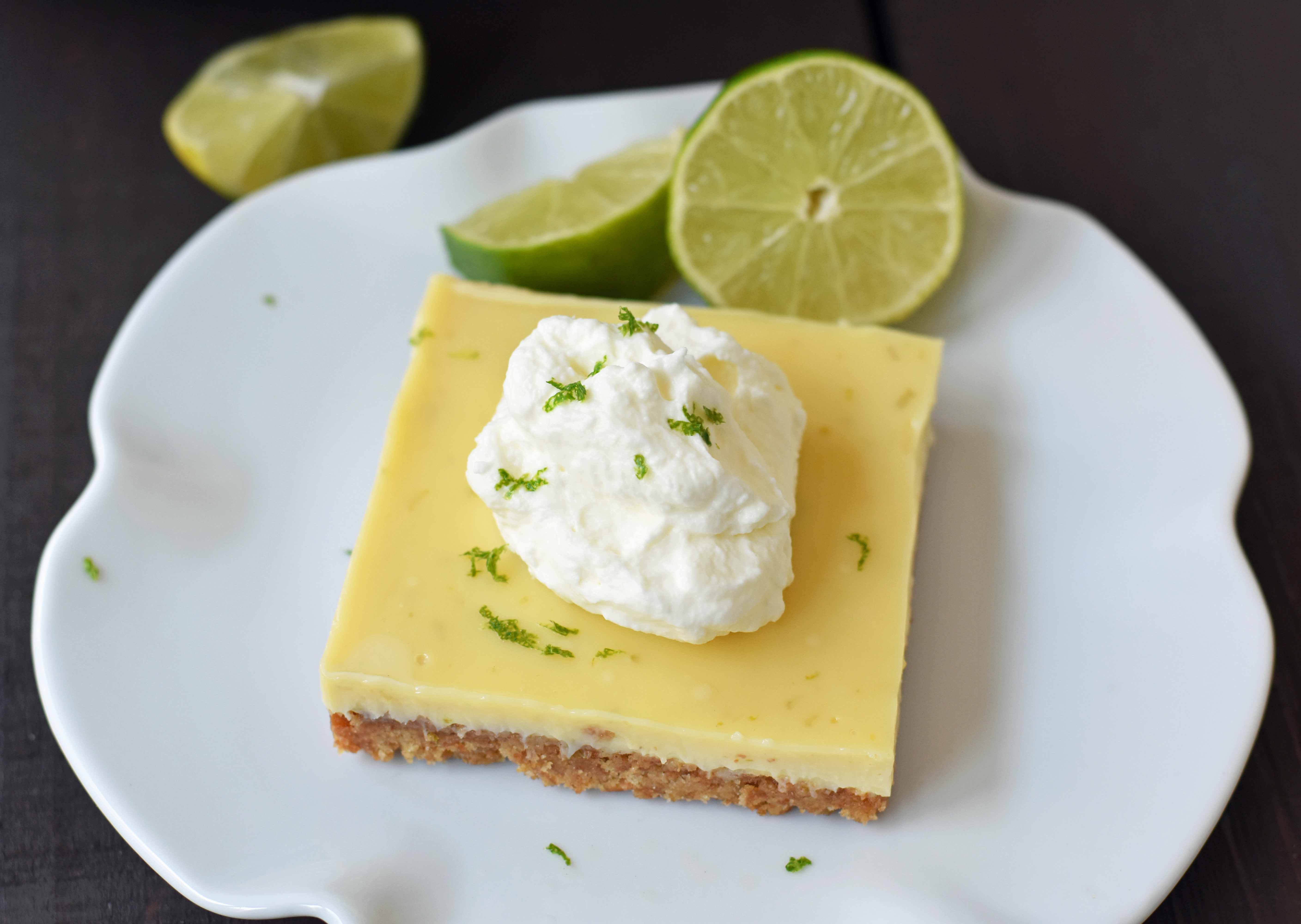 Key Lime Cream Pie Bars made with a buttery graham cracker crust and sweet, tart, and creamy key lime filling and topped with homemade whipped cream. A beautiful and delicious dessert bar recipe. www.modernhoney.com