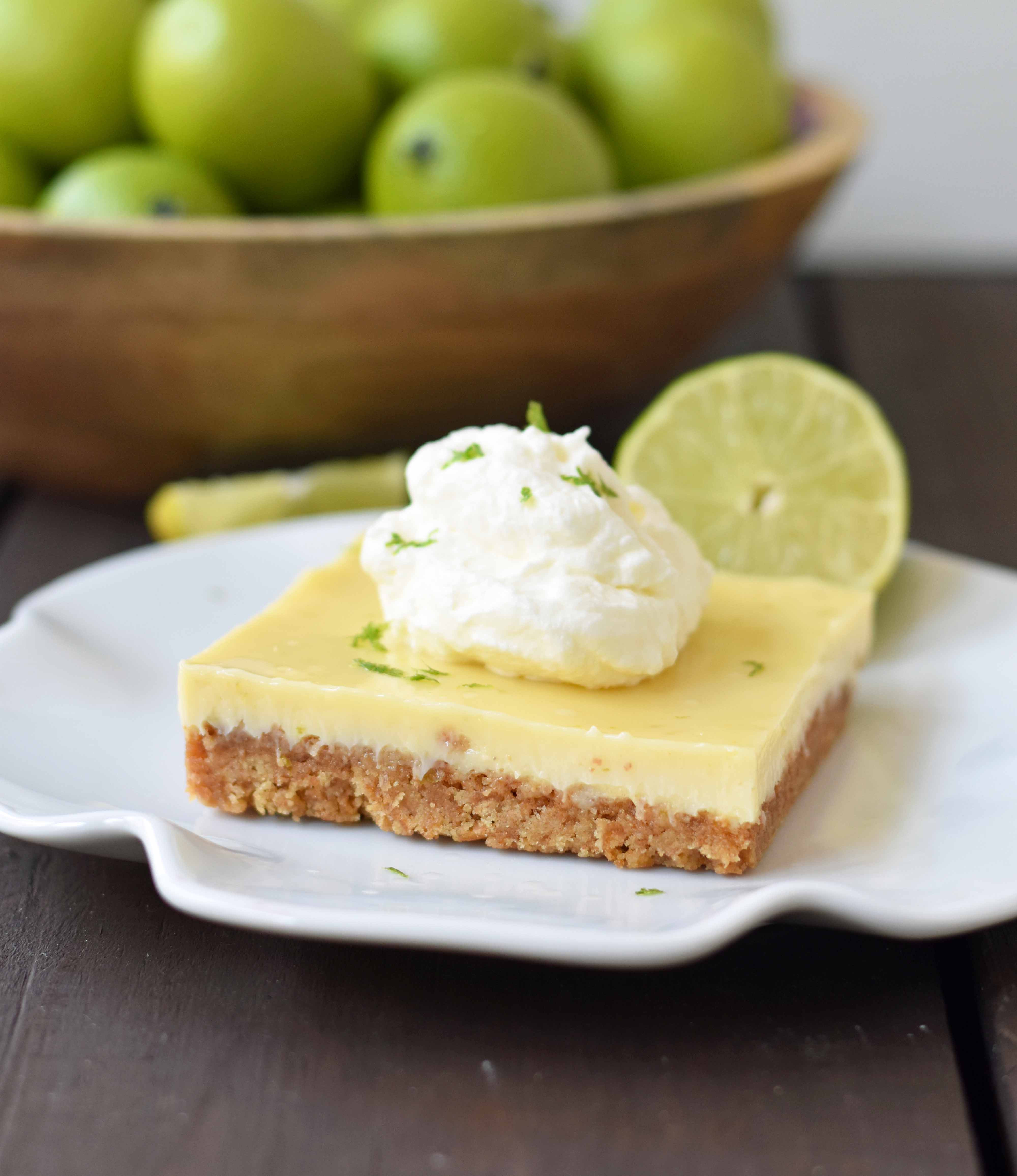 Key Lime Cream Pie Bars made with a buttery graham cracker crust and sweet, tart, and creamy key lime filling and topped with homemade whipped cream. A beautiful and delicious dessert bar recipe. www.modernhoney.com
