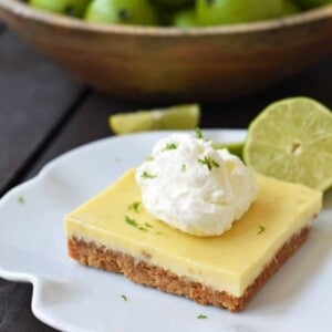 Key Lime Cream Pie Bars made with a buttery graham cracker crust and sweet, tart, and creamy key lime filling and topped with homemade whipped cream. A beautiful and delicious dessert bar recipe. www.modernhoney.com