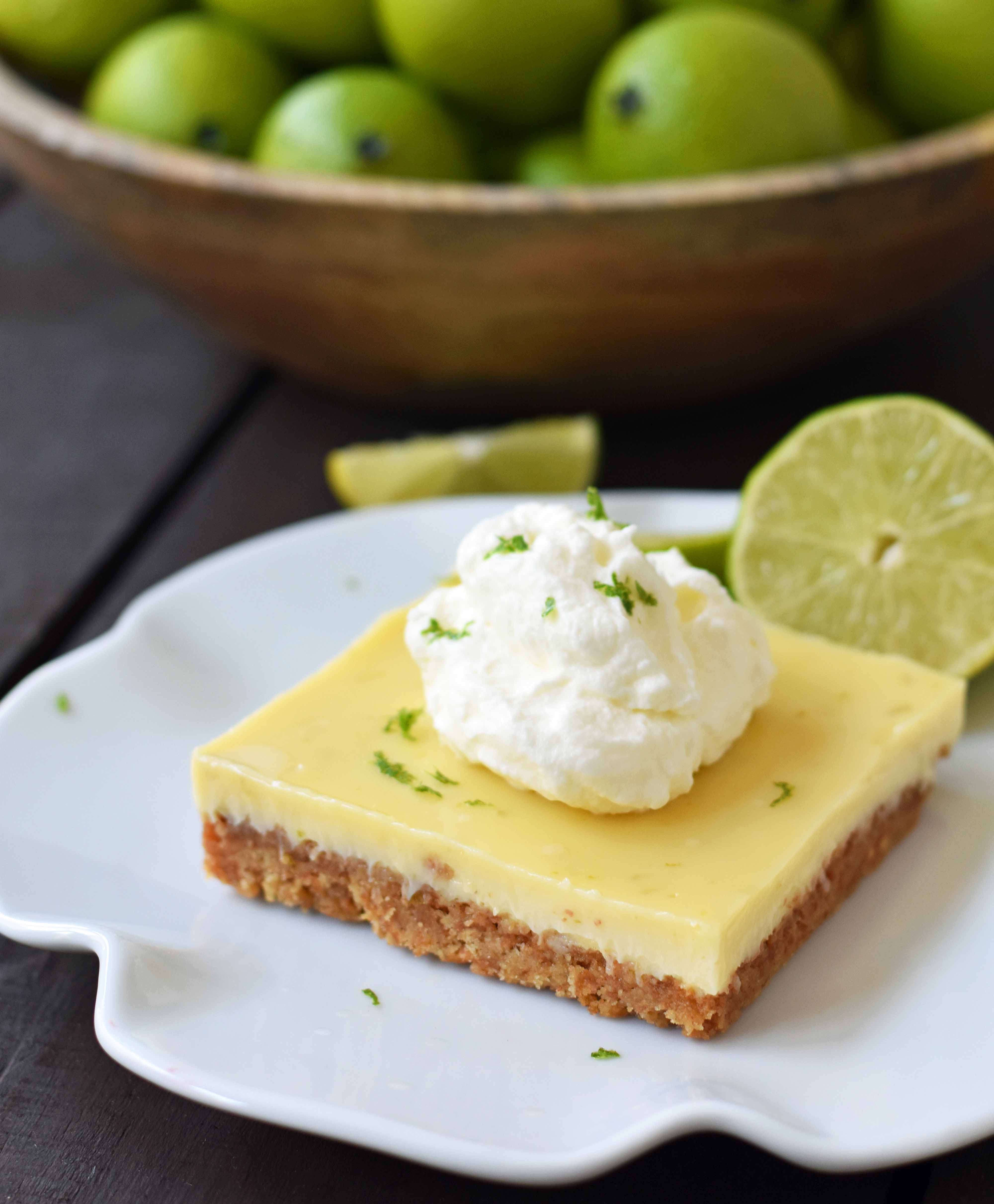 Key Lime Cream Pie Bars made with a buttery graham cracker crust and sweet, tart, and creamy key lime filling and topped with homemade whipped cream. A beautiful and delicious dessert bar recipe. www.modernhoney.com