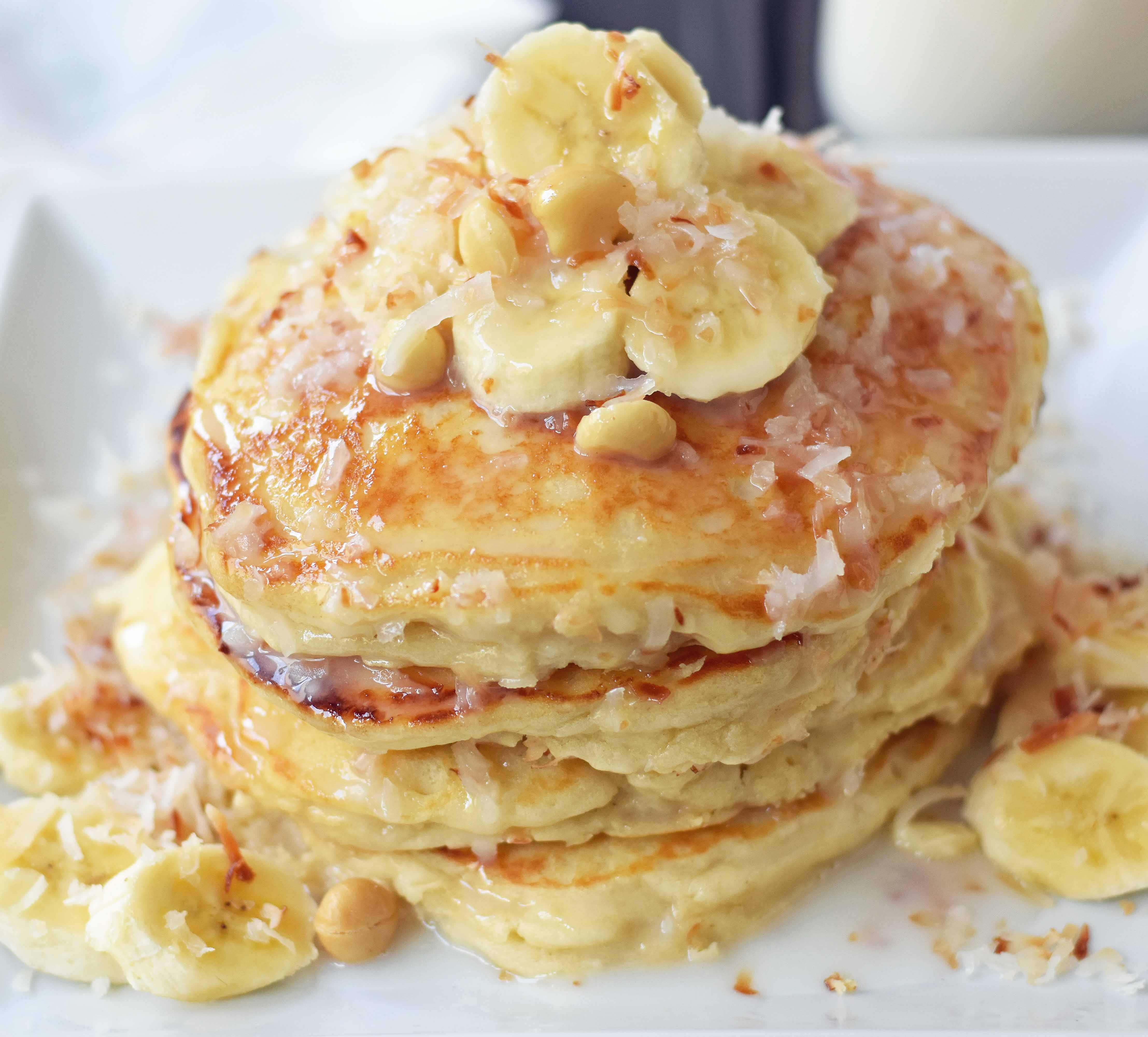 Toasted Coconut Macadamia Pancakes with Coconut Syrup are the most perfect tropical pancakes. Light and fluffy toasted coconut pancakes topped with homemade coconut syrup and macadamia nuts. www.modernhoney.com