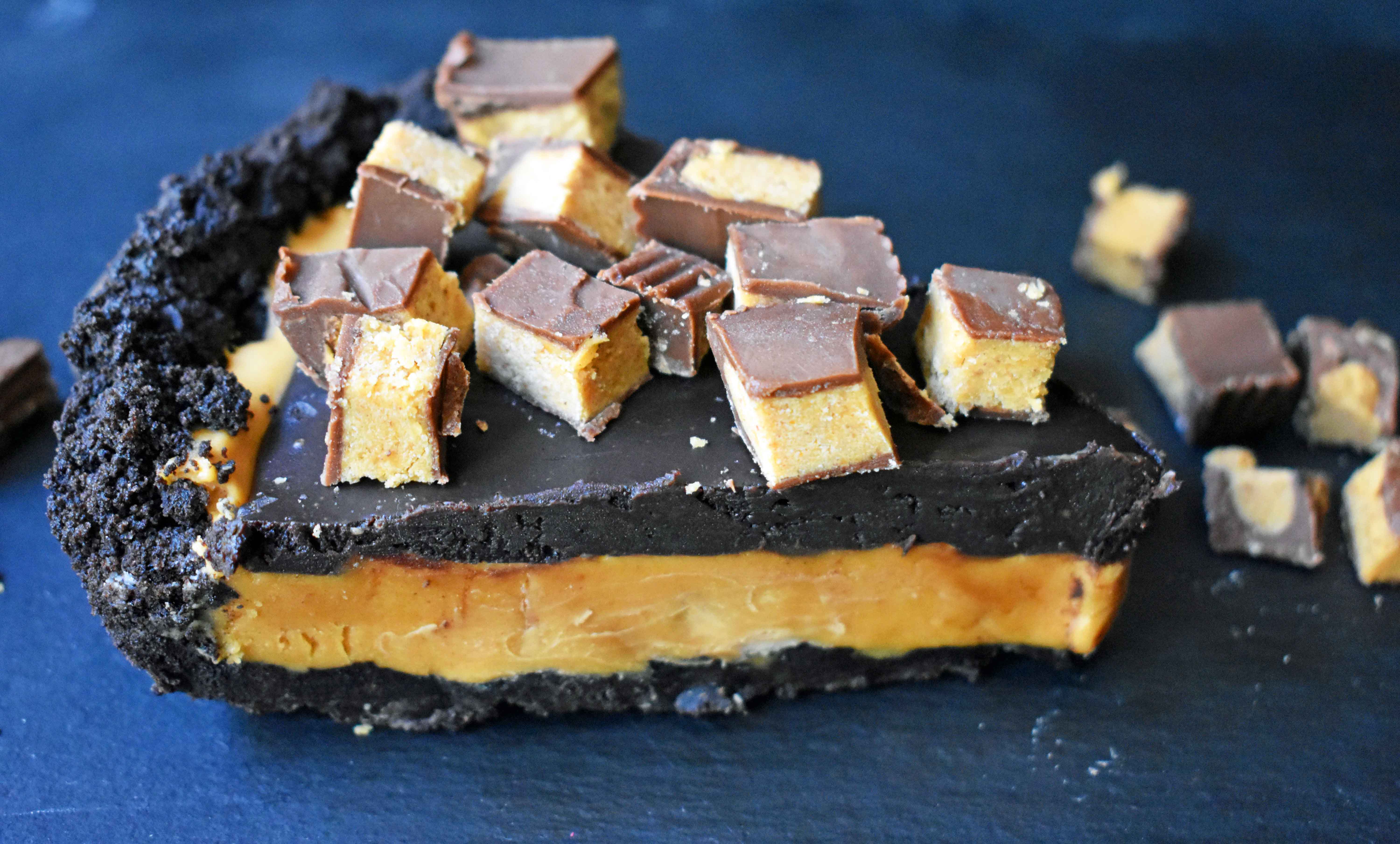 Reese's Chocolate Peanut Butter Cup Pie is made with an OREO Cookie Crust, Creamy Peanut Butter Filling, Chocolate Ganache, and topped with Reese's Peanut Butter Cups. A chocolate peanut butter lover's dream pie! A no-bake chocolate peanut butter pie with an OREO cookie crust will be a favorite dessert! www.modernhoney.com