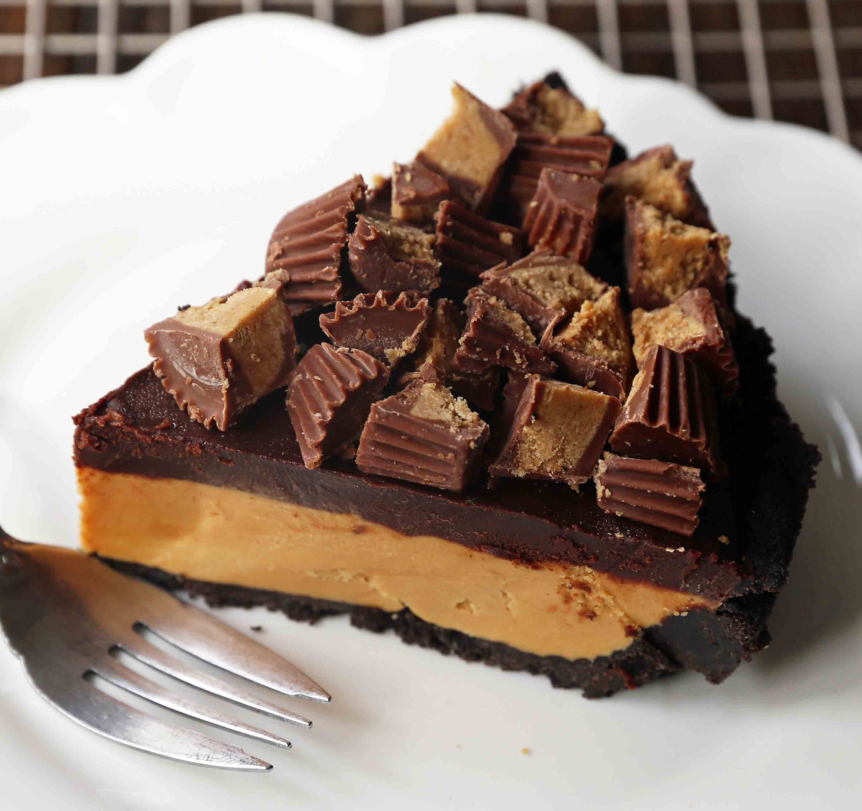 Chocolate Peanut Butter Cup Pie. Homemade chocolate peanut butter pie with an OREO cookie crust, creamy peanut butter mousse filling, and topped with chocolate ganache and peanut butter cups. www.modernhoney.com #peanutbutter #chocolatepeanutbutter #pie #pies #pierecipe 