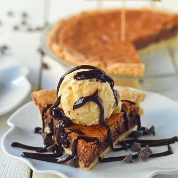 Chocolate Chip Cookie Pie with homemade chocolate chip cookie dough baked in a buttery flaky pie crust and topped with vanilla bean ice cream and hot fudge. The BEST Chocolate Chip Cookie Pie Recipe. www.modernhoney.com