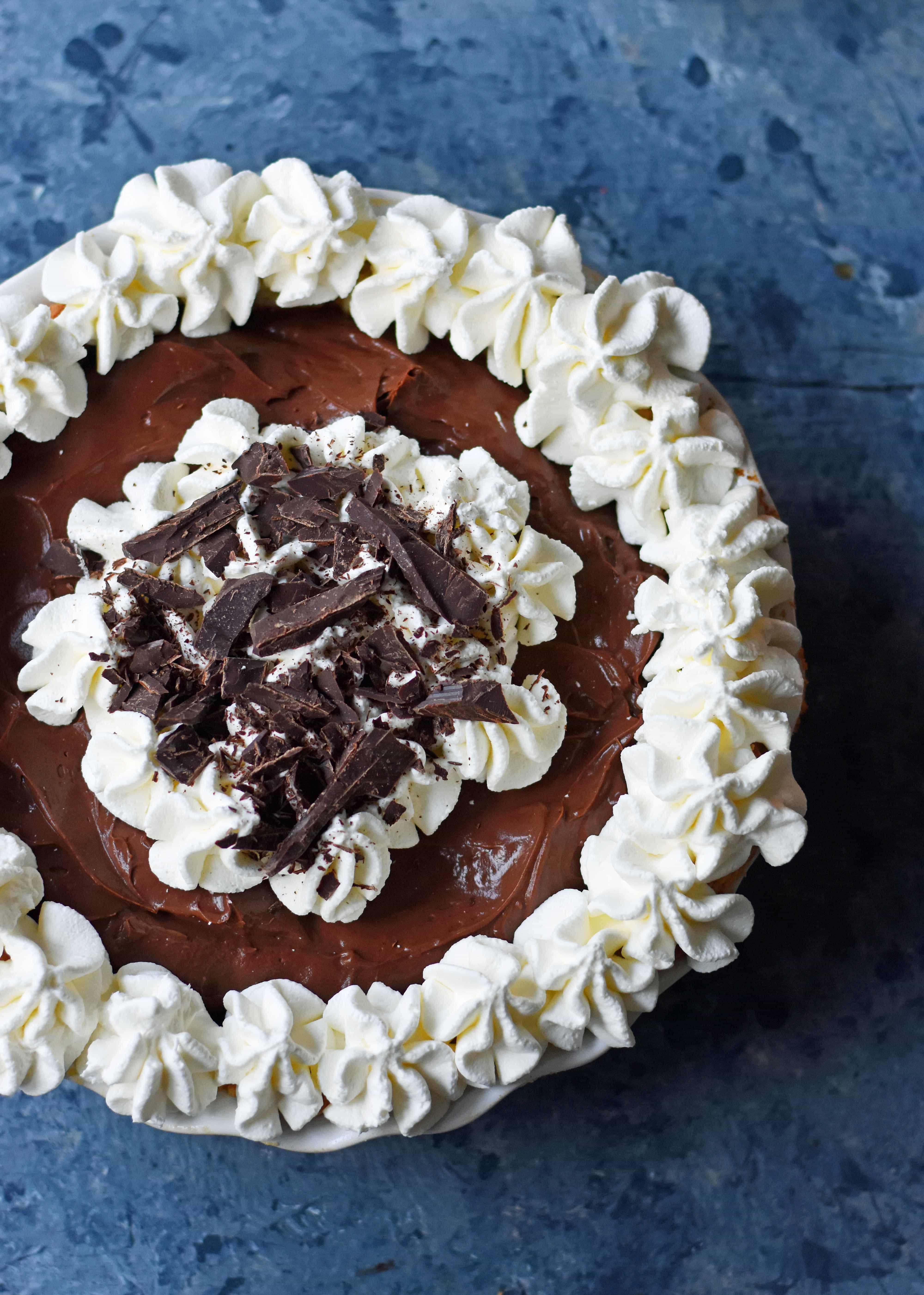 Chocolate Cream Pie made with decadent semi-sweet chocolate custard and topped with homemade whipped cream and shaved chocolate. A chocolate lover's dream pie with homemade chocolate custard and whipped cream. www.modernhoney.com