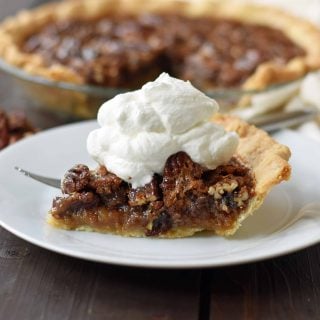 Old-Fashioned Pecan Pie made with a silky smooth brown sugar butter filling with crunchy pecans. Baked in a buttery flaky pie crust and topped with homemade whipped cream. A classic Southern Pecan Pie recipe. www.modernhoney.com
