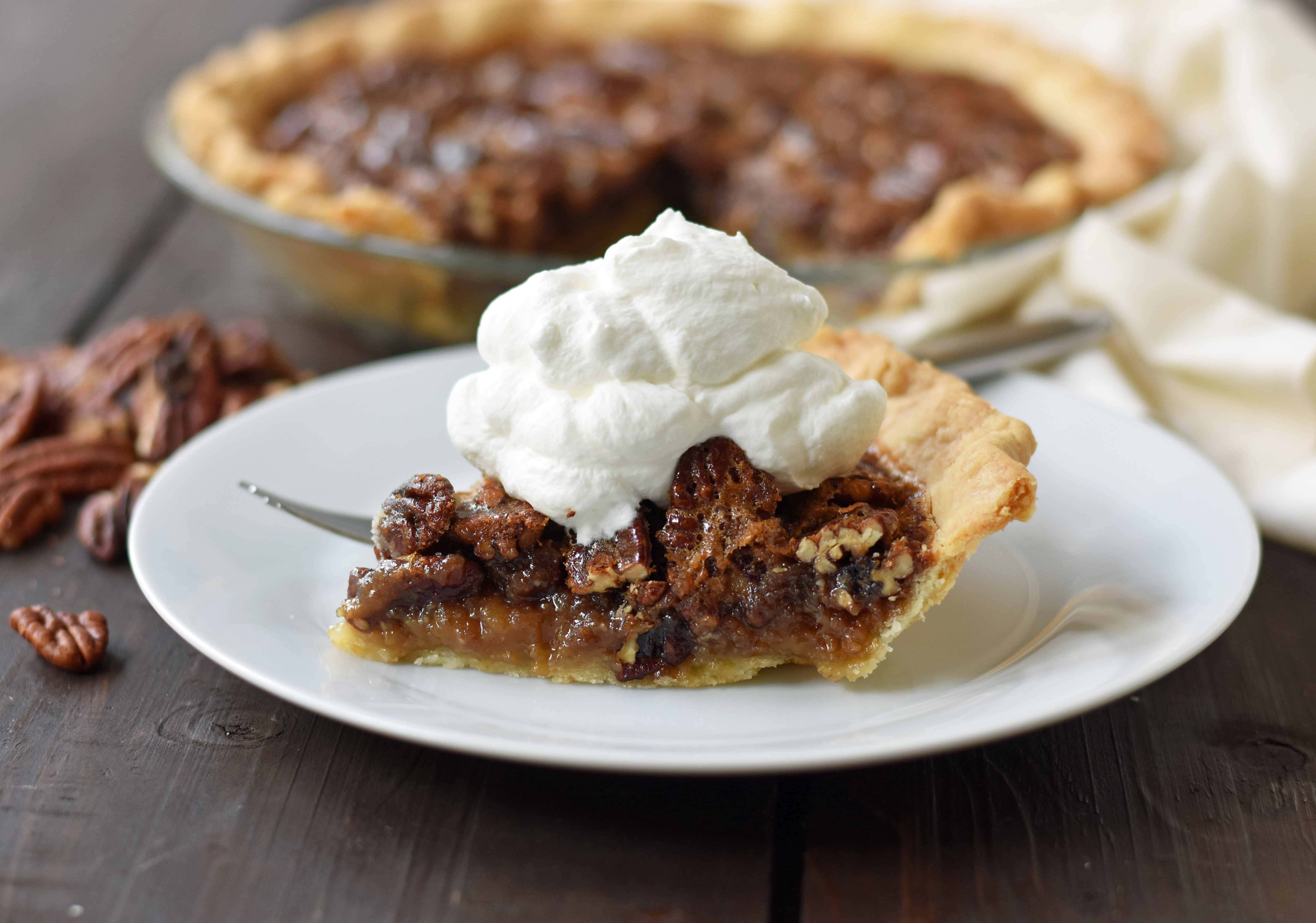 Old-Fashioned Pecan Pie made with a silky smooth brown sugar butter filling with crunchy pecans. Baked in a buttery flaky pie crust and topped with homemade whipped cream. A classic Southern Pecan Pie recipe. www.modernhoney.com