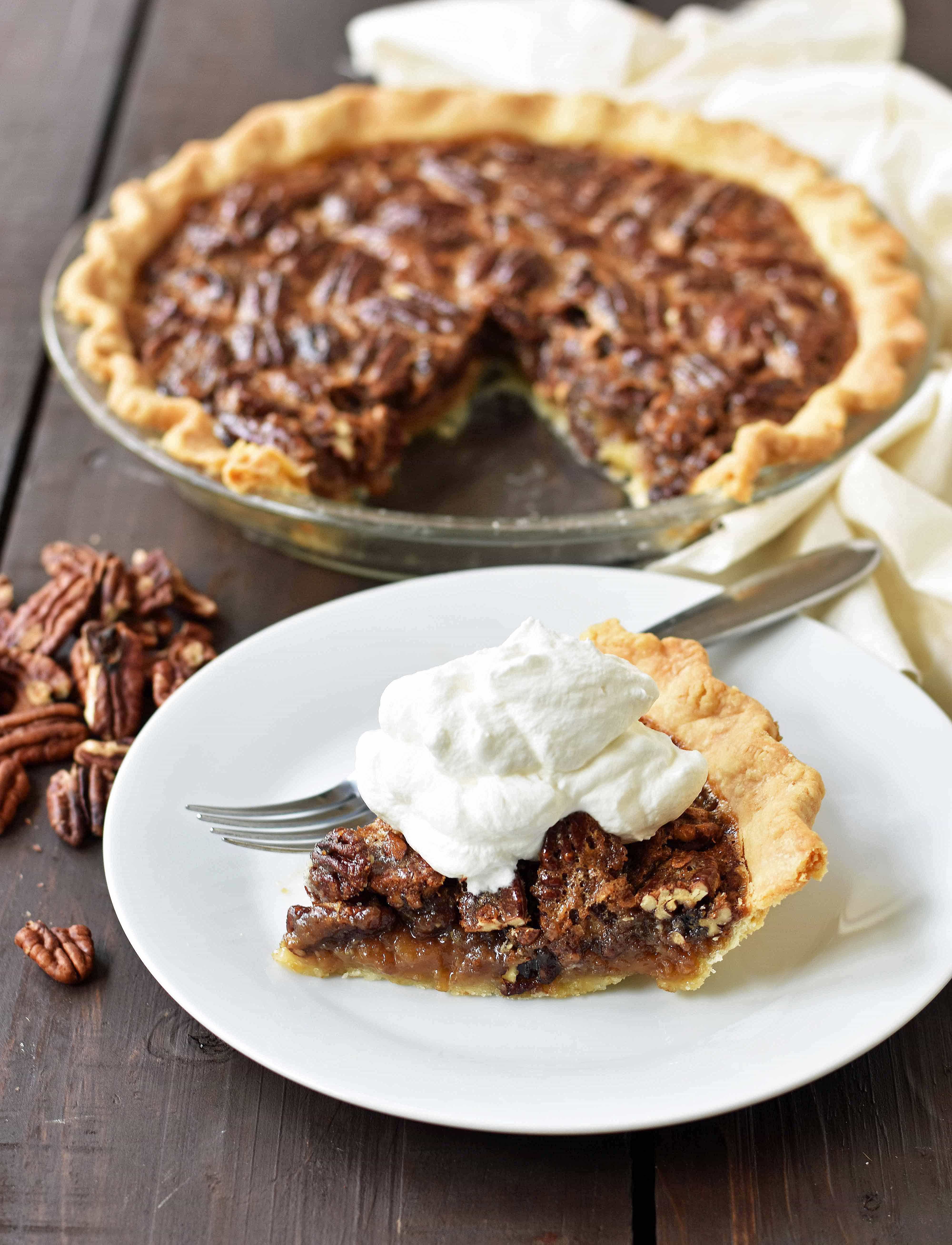 Old-Fashioned Pecan Pie made with a silky smooth brown sugar butter filling with crunchy pecans. Baked in a buttery flaky pie crust and topped with homemade whipped cream. A classic Southern Pecan Pie recipe. www.modernhoney.com