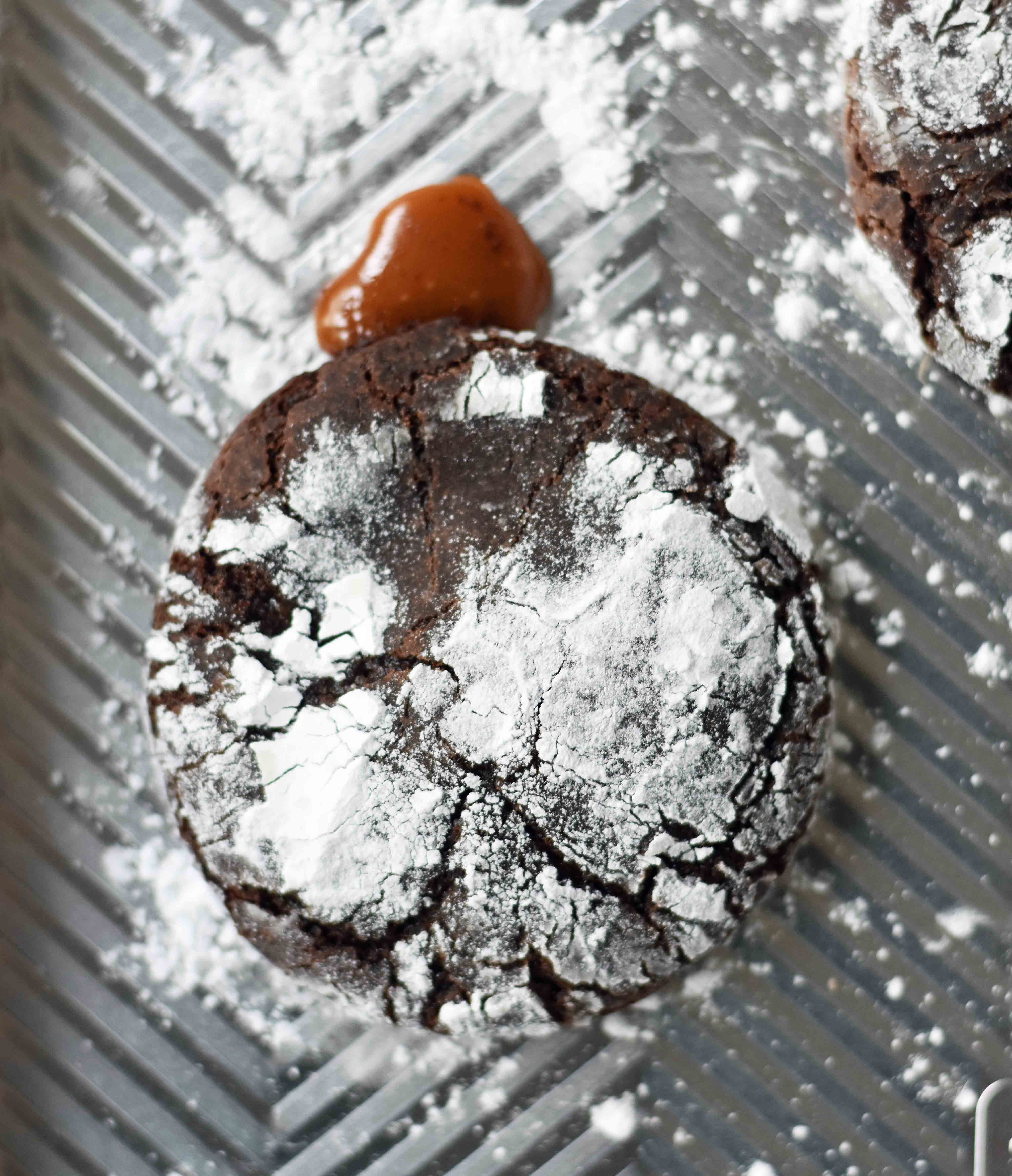 Caramel Filled Chocolate Crinkle Cookies. Soft chewy chocolate cookies with soft caramel center and roll into powdered sugar. A popular chocolate caramel filled cookie. www.modernhoney.com