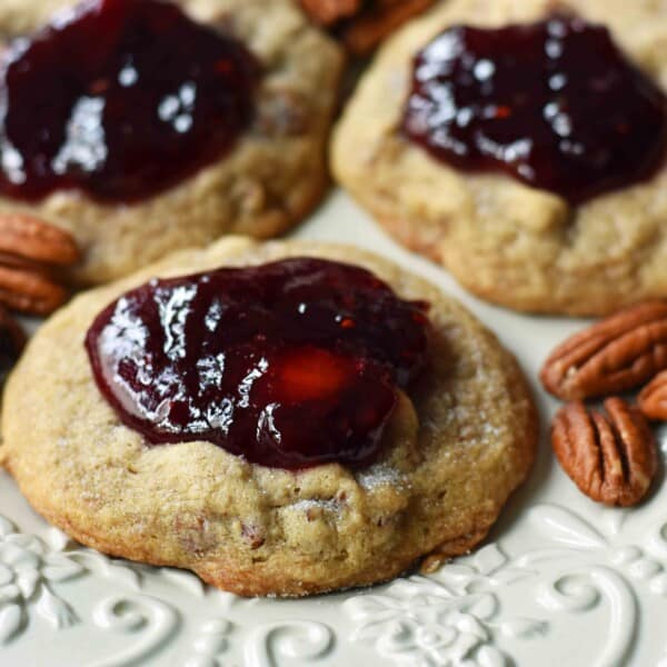 Cream Cheese Pecan Jam Thumbprint Cookies are a chewy pecan cookie baked until golden and topped with fresh berry jam. A soft and chewy cream cheese pecan cookie topped with fresh jam. www.modernhoney.com