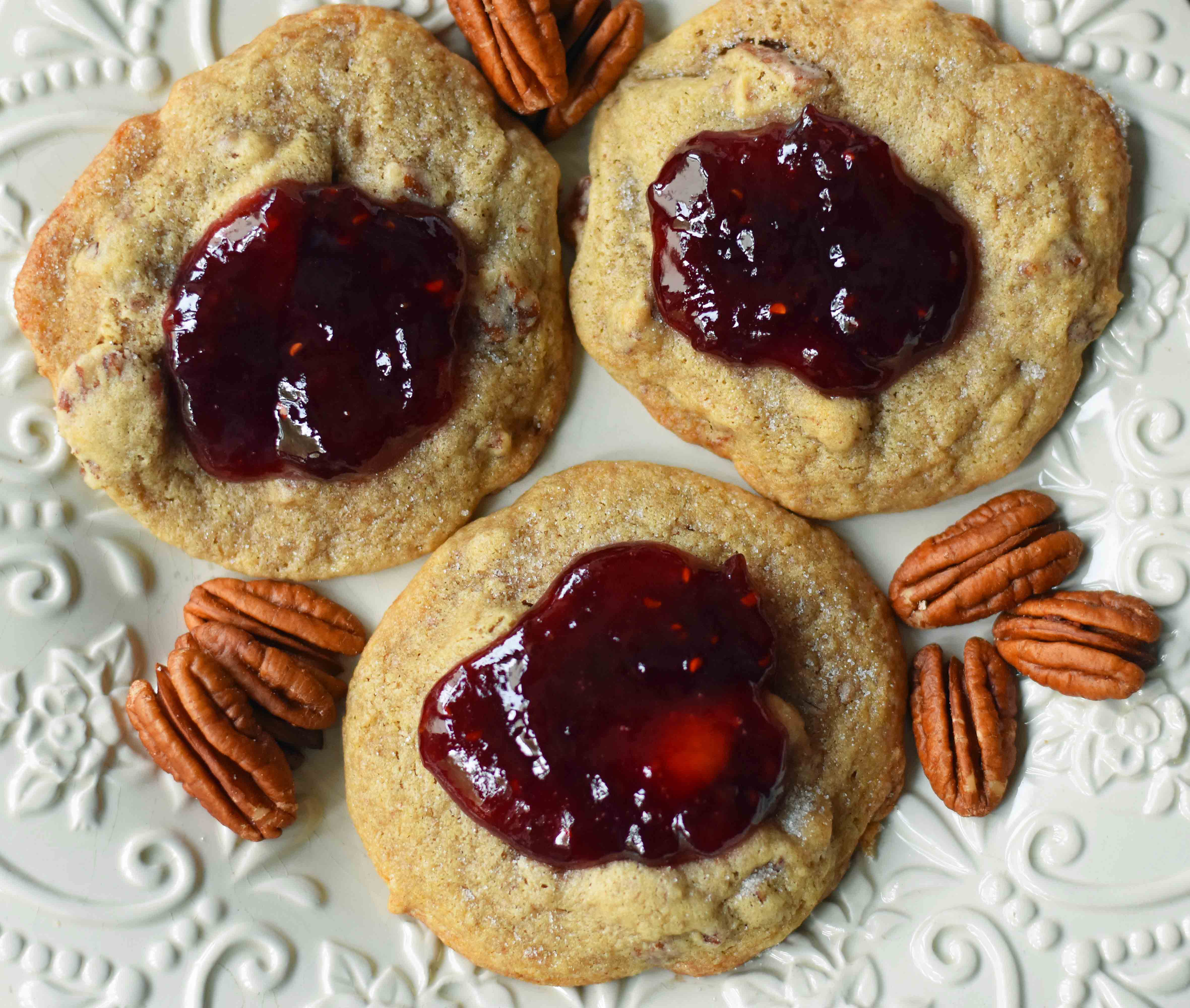 Cream Cheese Pecan Jam Thumbprint Cookies are a chewy pecan cookie baked until golden and topped with fresh berry jam. A soft and chewy cream cheese pecan cookie topped with fresh jam. www.modernhoney.com