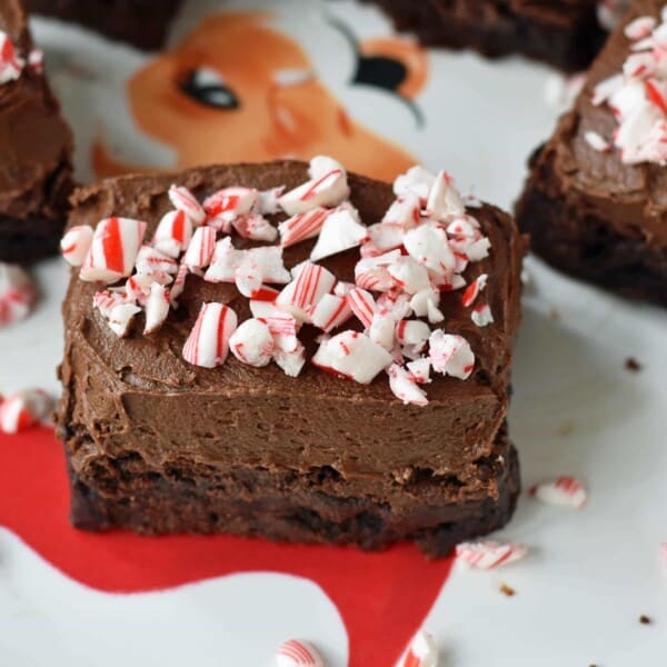 Peppermint Frosted Chocolate Brownies. Rich decadent chewy chocolate brownies topped with homemade silky smooth chocolate frosting and topped with candy canes. A chocolate frosted brownie with candy canes. www.modernhoney.com