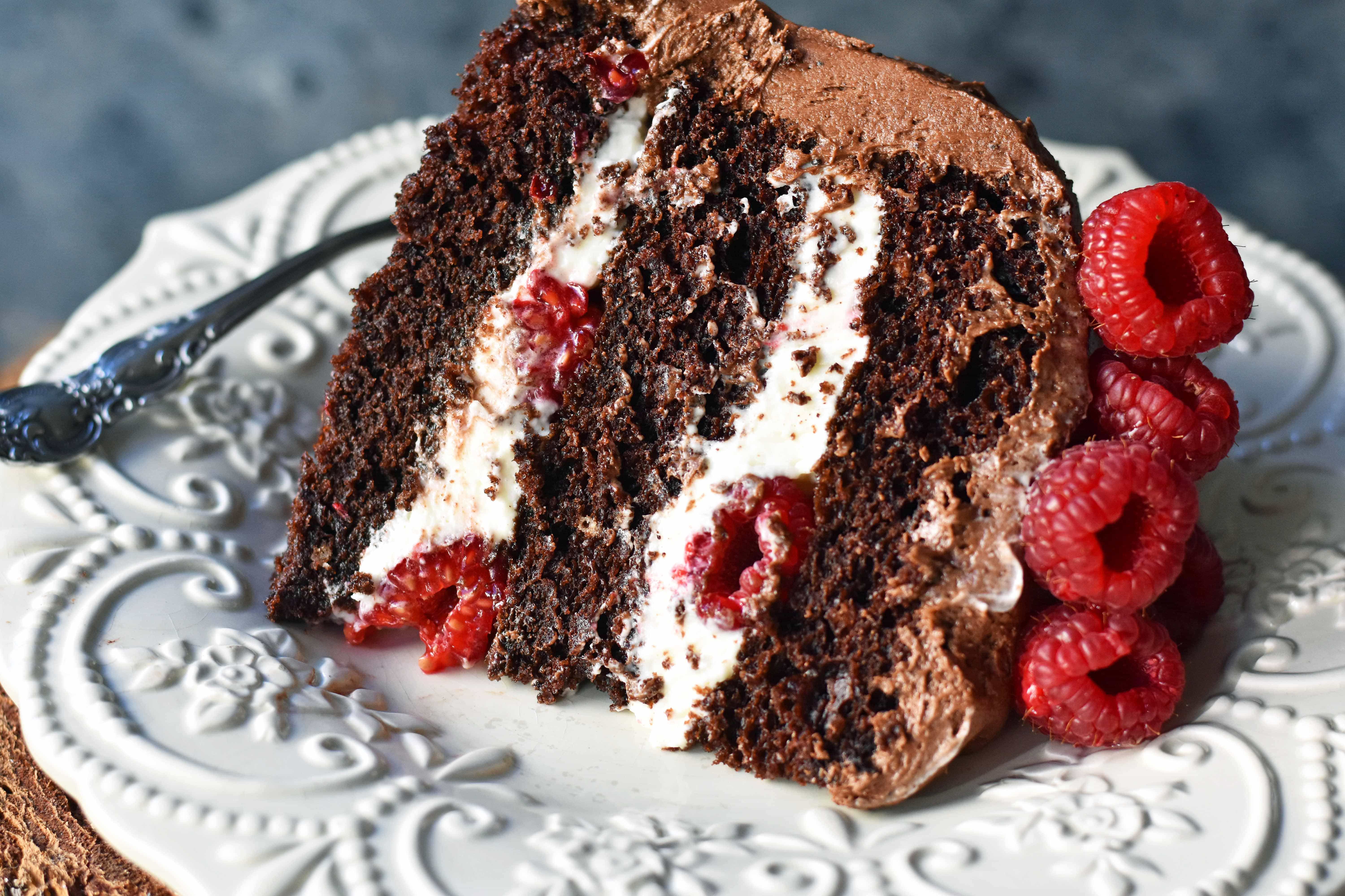 Rich chocolate cake layered with whipped cream cheese raspberry filling, topped with creamy chocolate frosting and fresh raspberries. Homemade BEST EVER Chocolate Cake with sweet whipped cream cheese raspberry filling topped with chocolate buttercream and raspberries. www.modernhoney.com