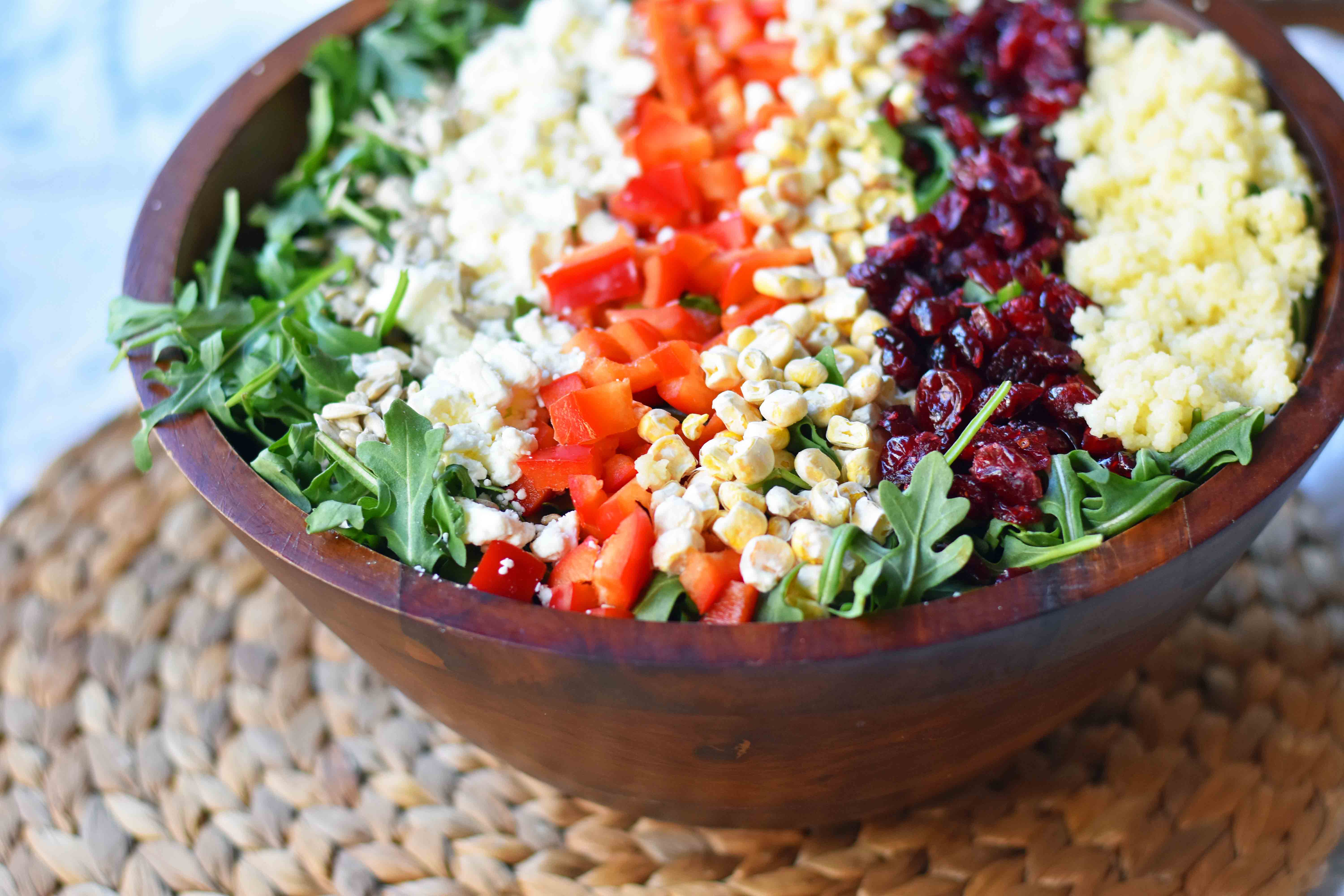 Chopped Salad with fresh arugula, dried cranberries, crunchy red peppers, feta cheese, sweet corn, and couscous tossed with a creamy basil dressing. A Wildflower copycat recipe. www.modernhoney.com