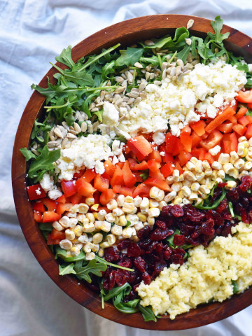 Chopped Salad with fresh arugula, dried cranberries, crunchy red peppers, feta cheese, sweet corn, and couscous tossed with a creamy basil dressing. A Wildflower copycat recipe. www.modernhoney.com