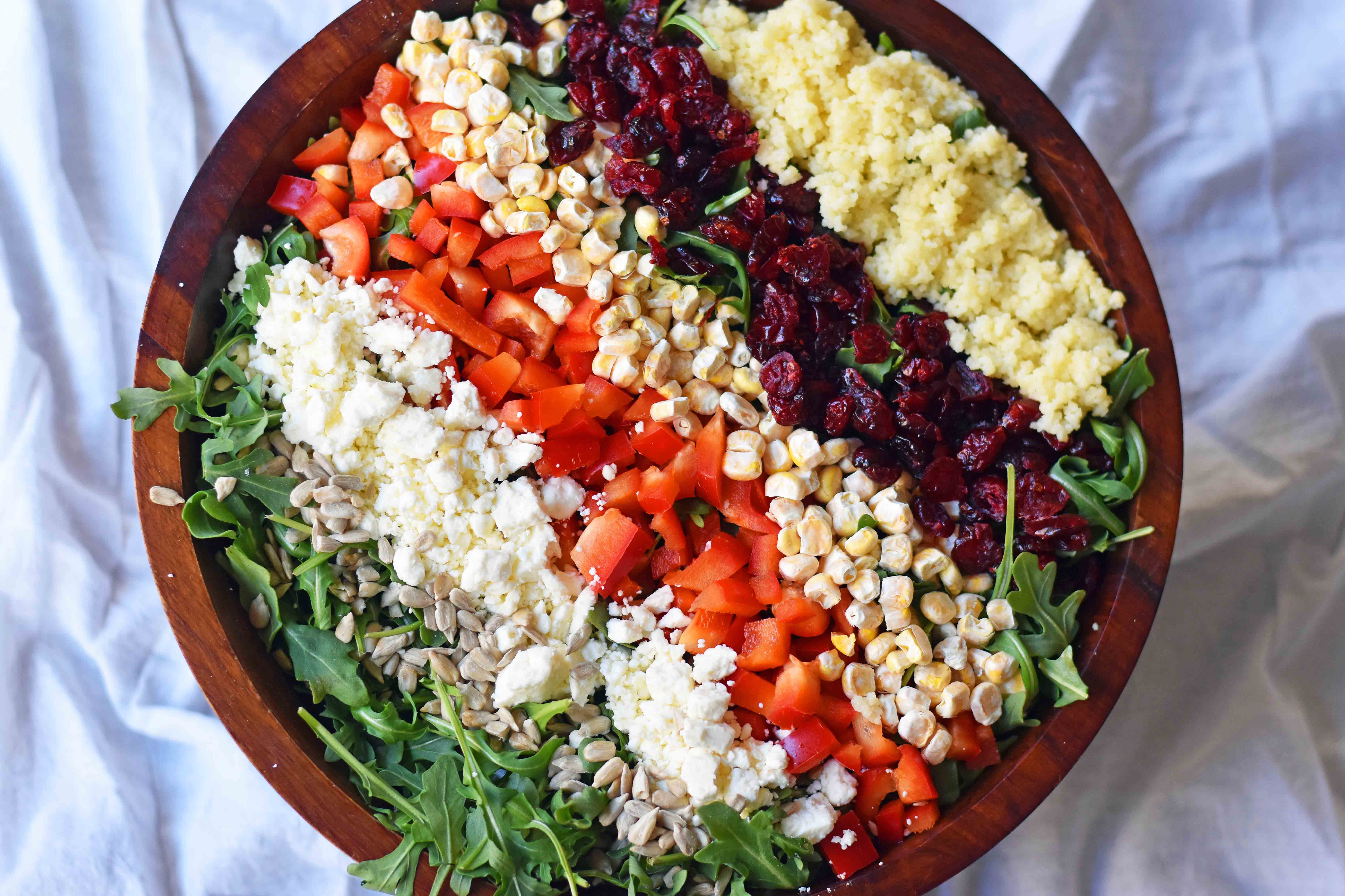 Chopped Salad with fresh arugula, dried cranberries, crunchy red peppers, feta cheese, sweet corn, and couscous tossed with a creamy basil dressing. A Wildflower copycat recipe. www.modernhoney.com