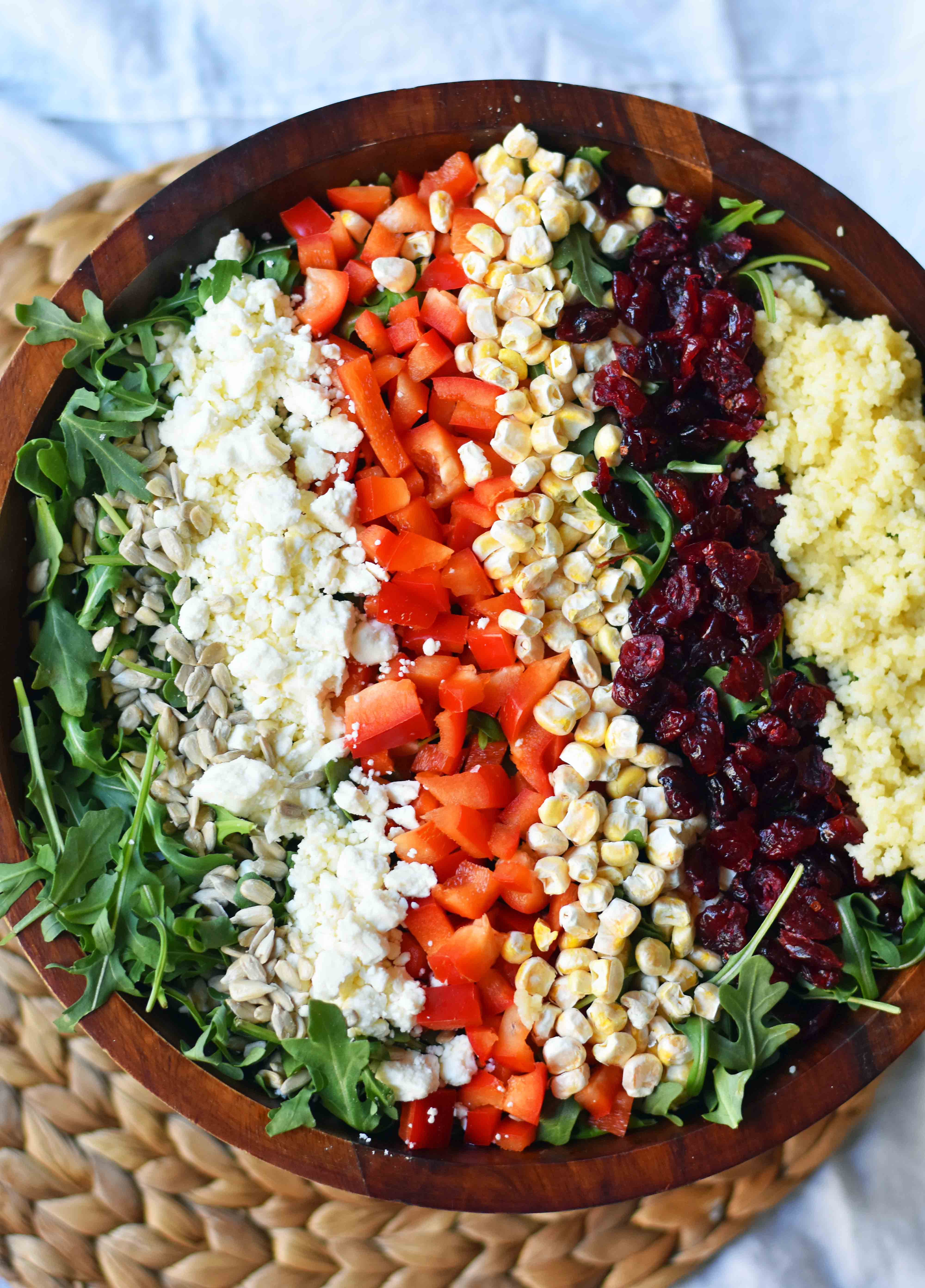 Chopped Salad with fresh arugula, dried cranberries, crunchy red peppers, feta cheese, sweet corn, and couscous tossed with a creamy basil dressing. A Wildflower copycat recipe. www.modernhoney.com