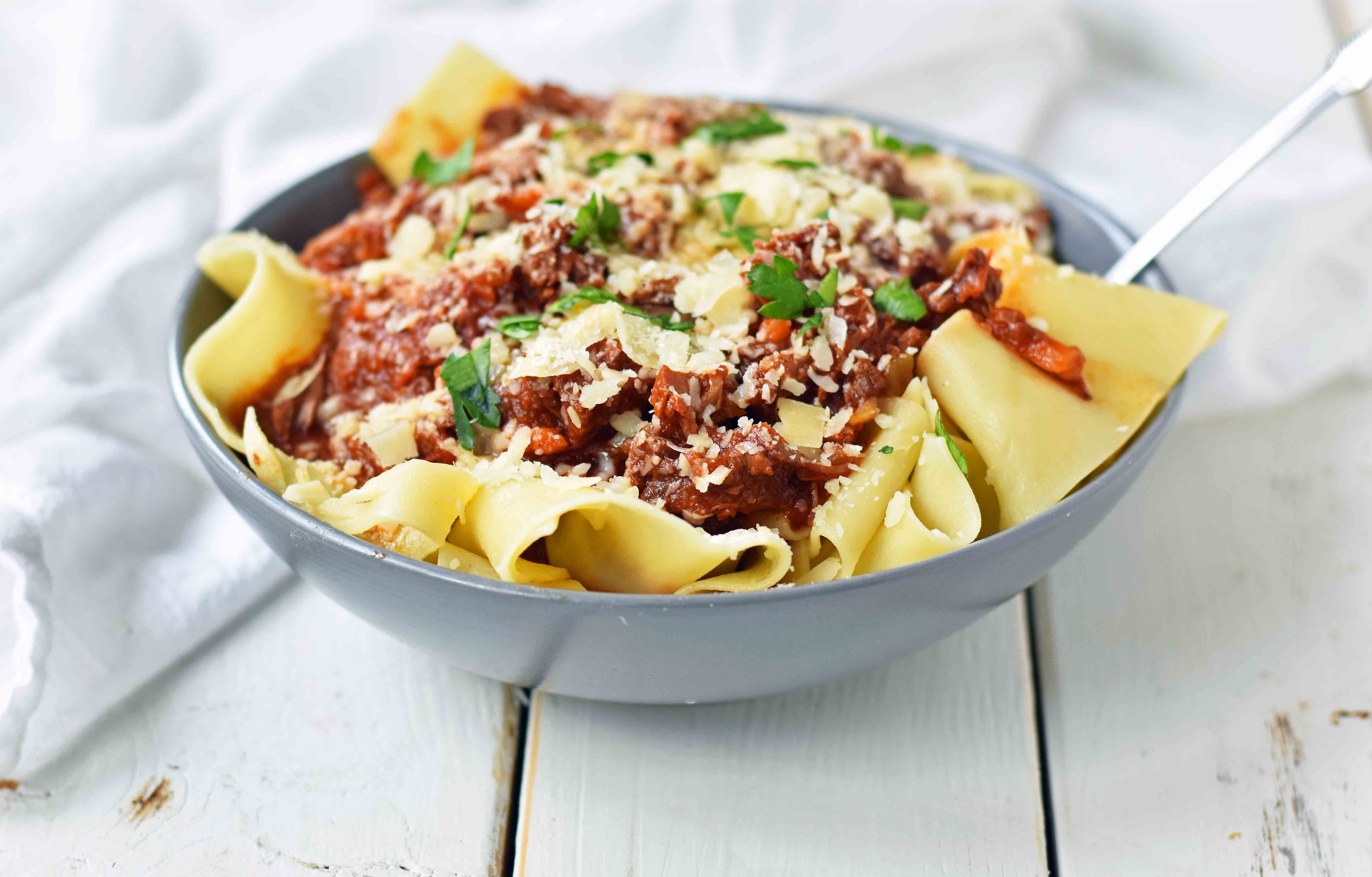 Slow Cooker Instant Pot Beef Ragu. This braised shredded beef ragu with pappardelle pasta can be made in a slow cooker or instant pot pressure cooker. It makes the most tender, flavorful beef in a rich, velvety sauce. It is the ultimate comfort meal in a bowl! This Beef Ragu can be put on top of spiralized vegetables, mashed potatoes, or polenta for a gluten-free dinner. www.modernhoney.com 