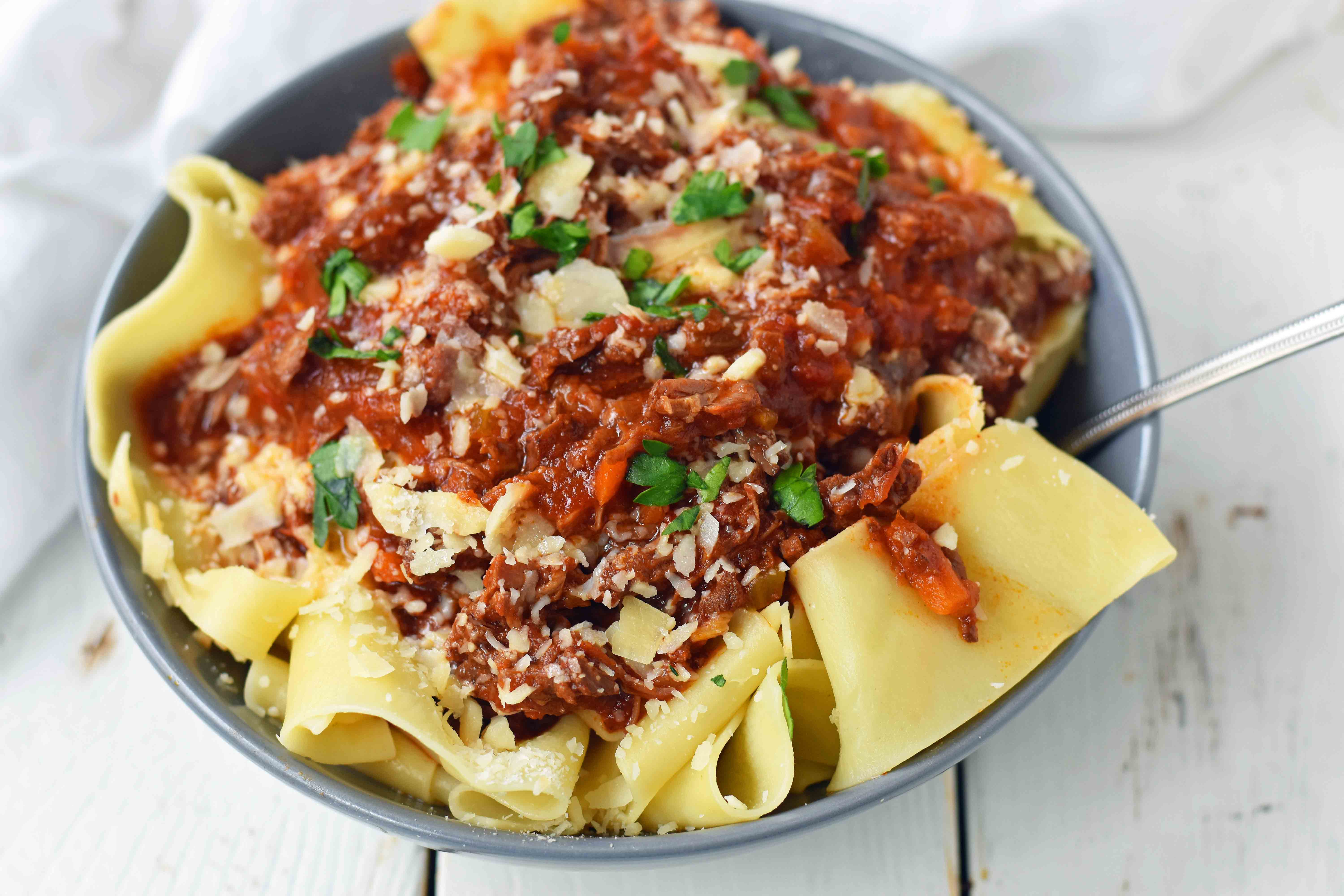 This braised shredded beef ragu with pappardelle pasta can be made in a slow cooker or instant pot pressure cooker. It makes the most tender, flavorful beef in a rich, velvety sauce. It is the ultimate comfort meal in a bowl! This Beef Ragu can be put on top of spiralized vegetables, mashed potatoes, or polenta for a gluten-free dinner. www.modernhoney.com 